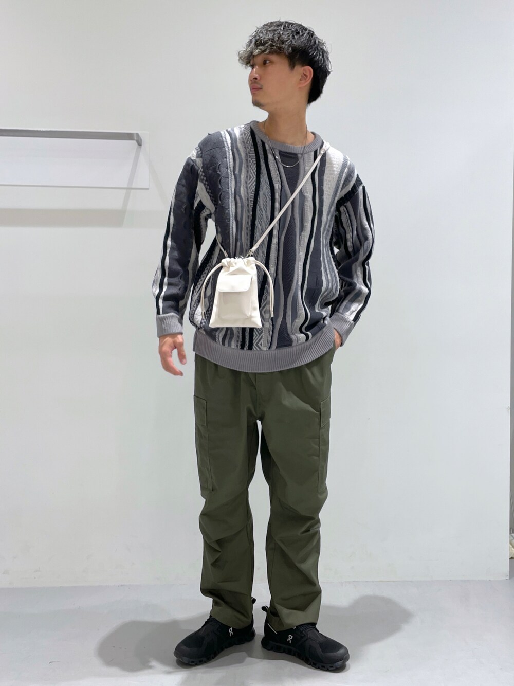 グリーン系のその他パンツ、グレー系のニット/セーター、ベージュ系のショルダーバッグを着用したメンズの冬コーディネートの1枚目の写真