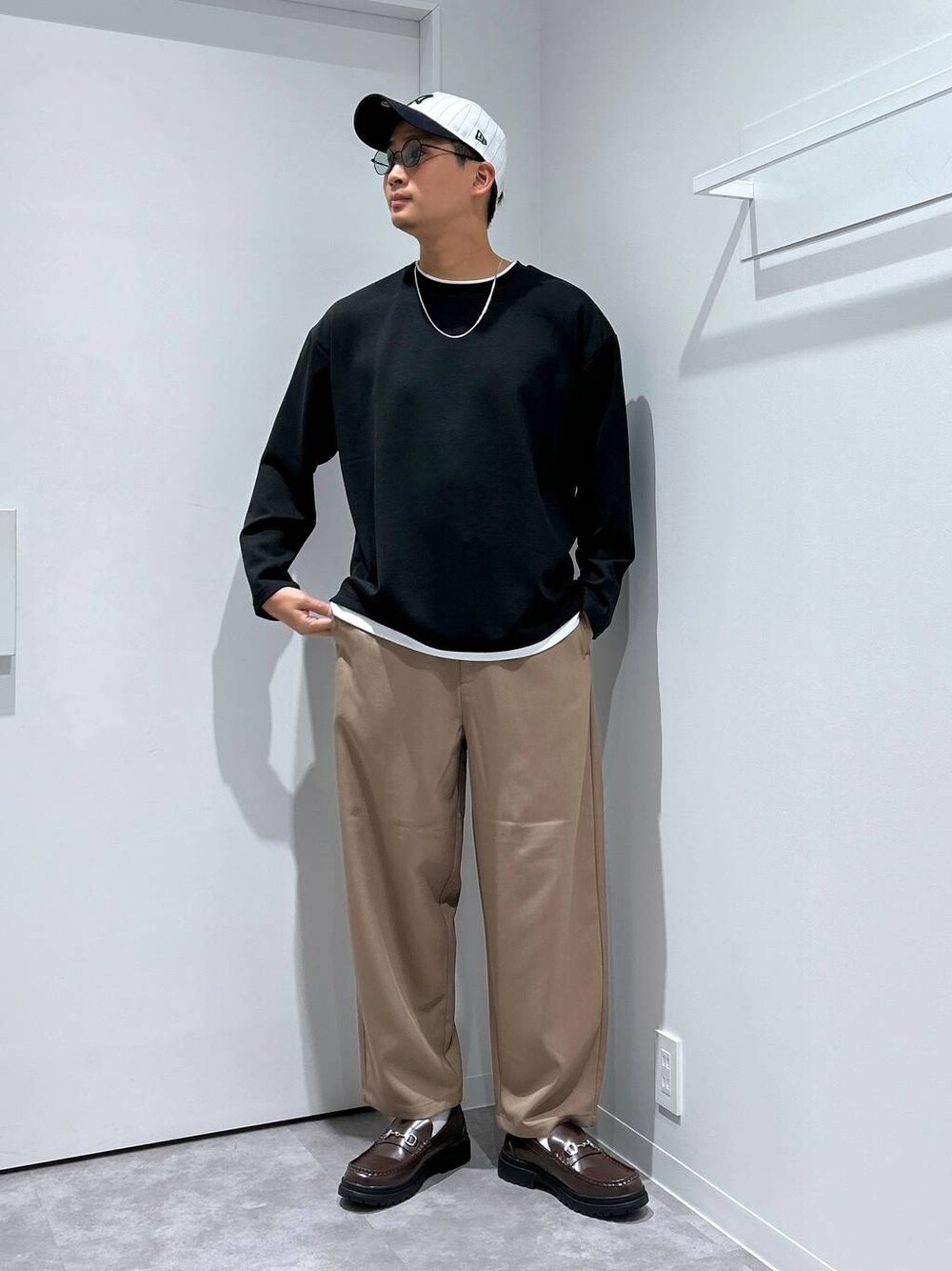 ブラック系のTシャツ/カットソー、ブラウン系のローファー、グリーン系のサングラスを着用したメンズの冬コーディネートの1枚目の写真