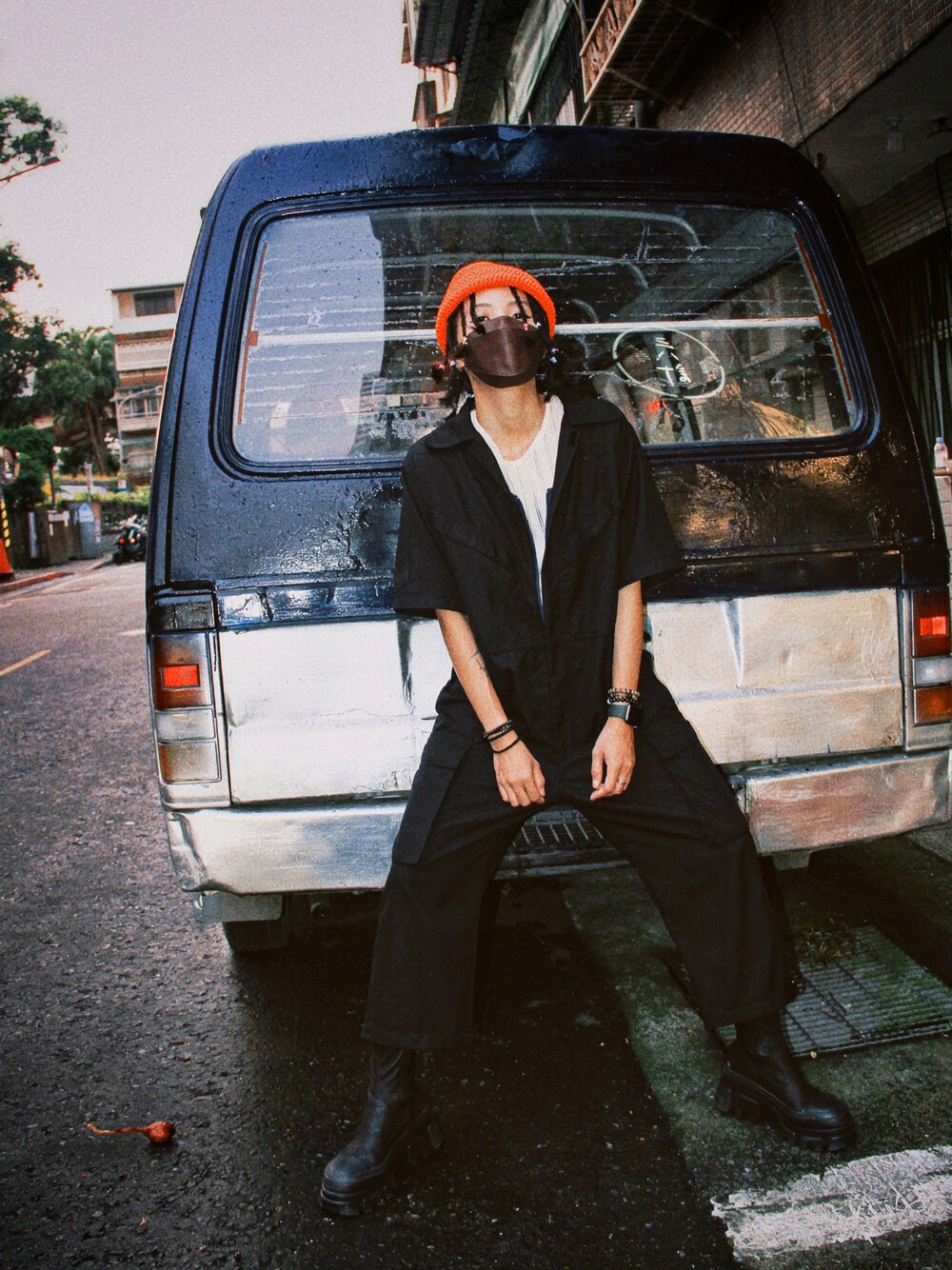 ホワイト系のニット/セーター、ブラック系のオールインワン・サロペット、オレンジ系のニットキャップ/ビーニーを着用したレディースの夏コーディネートの1枚目の写真