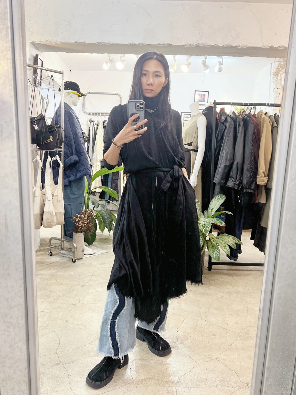 ブラック系のワンピース、ブルー系のデニムパンツを着用したレディースの冬コーディネートの1枚目の写真