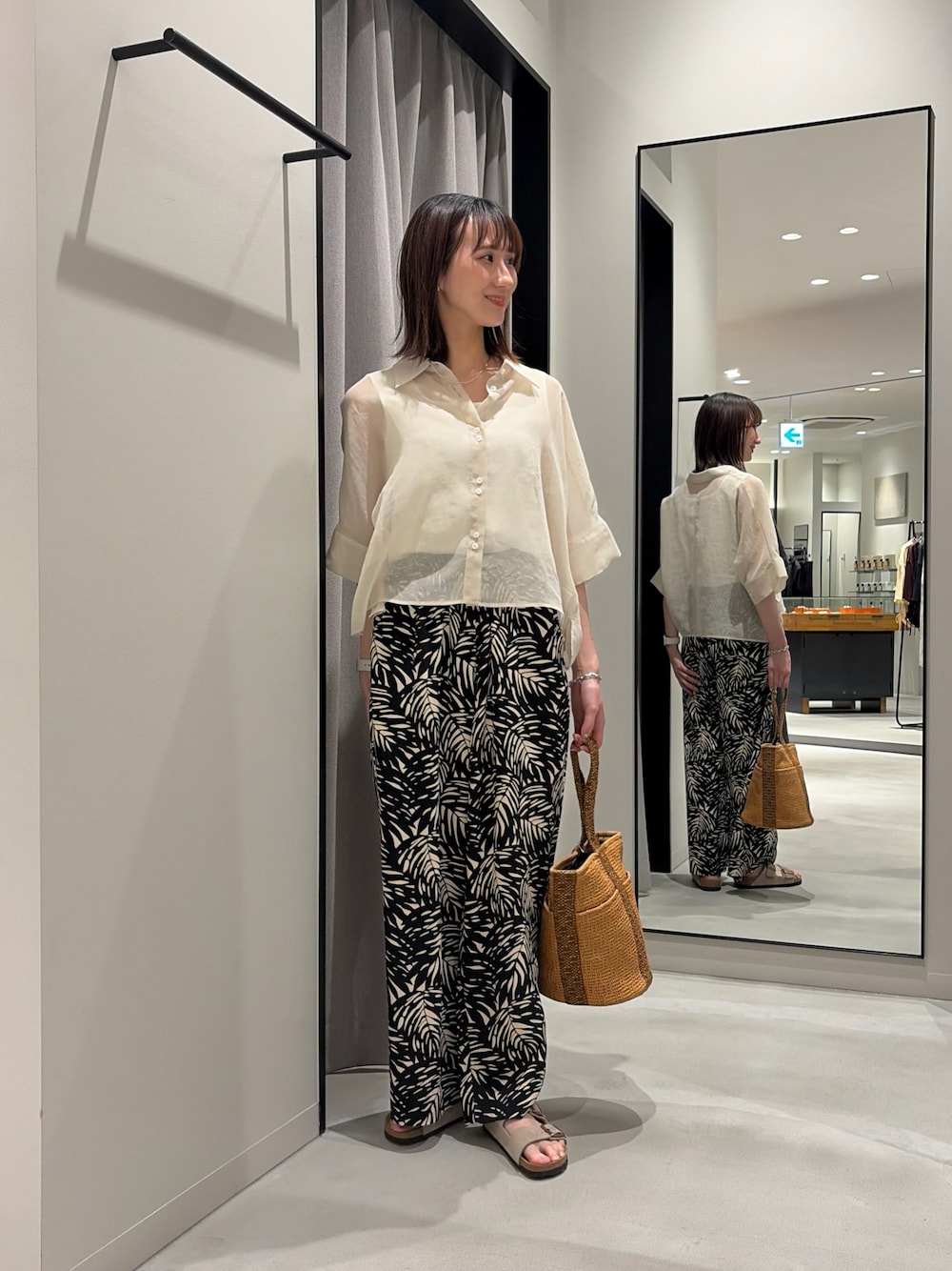 ブラック系のその他パンツ、ベージュ系のバッグ、ベージュ系のサンダルを着用したレディースの春コーディネートの1枚目の写真