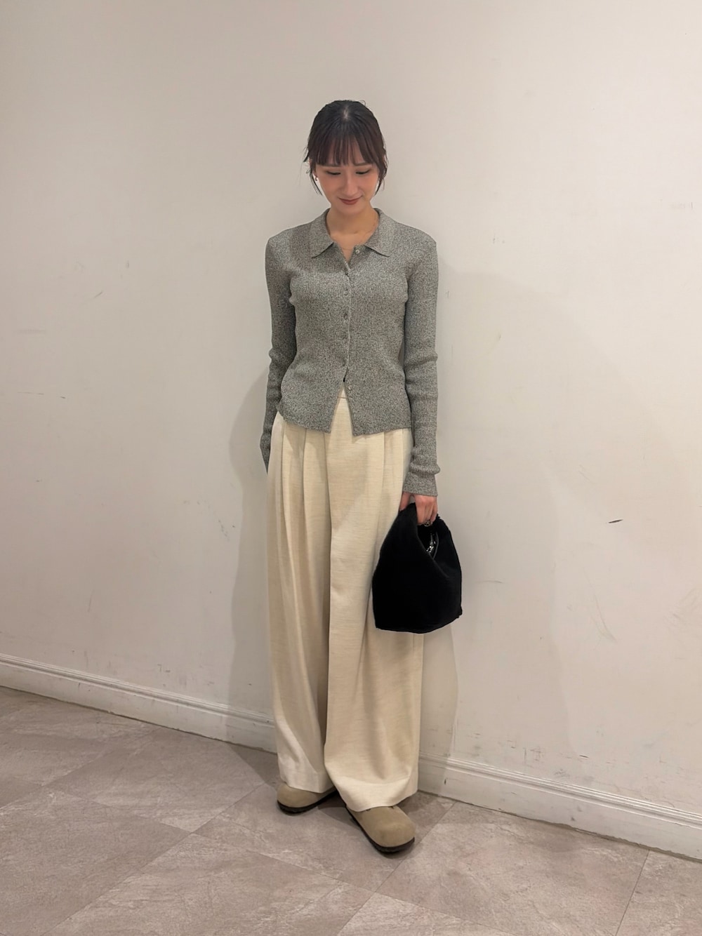 グレー系のニット/セーター、ホワイト系のその他パンツ、ブラック系のハンドバッグを着用したレディースの秋コーディネートの1枚目の写真