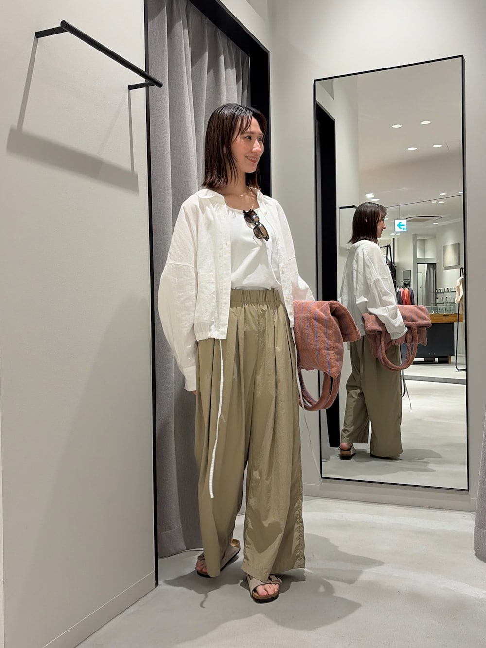 ベージュ系のその他パンツ、ベージュ系のサンダル、イエロー系のトートバッグを着用したレディースの春コーディネートの1枚目の写真