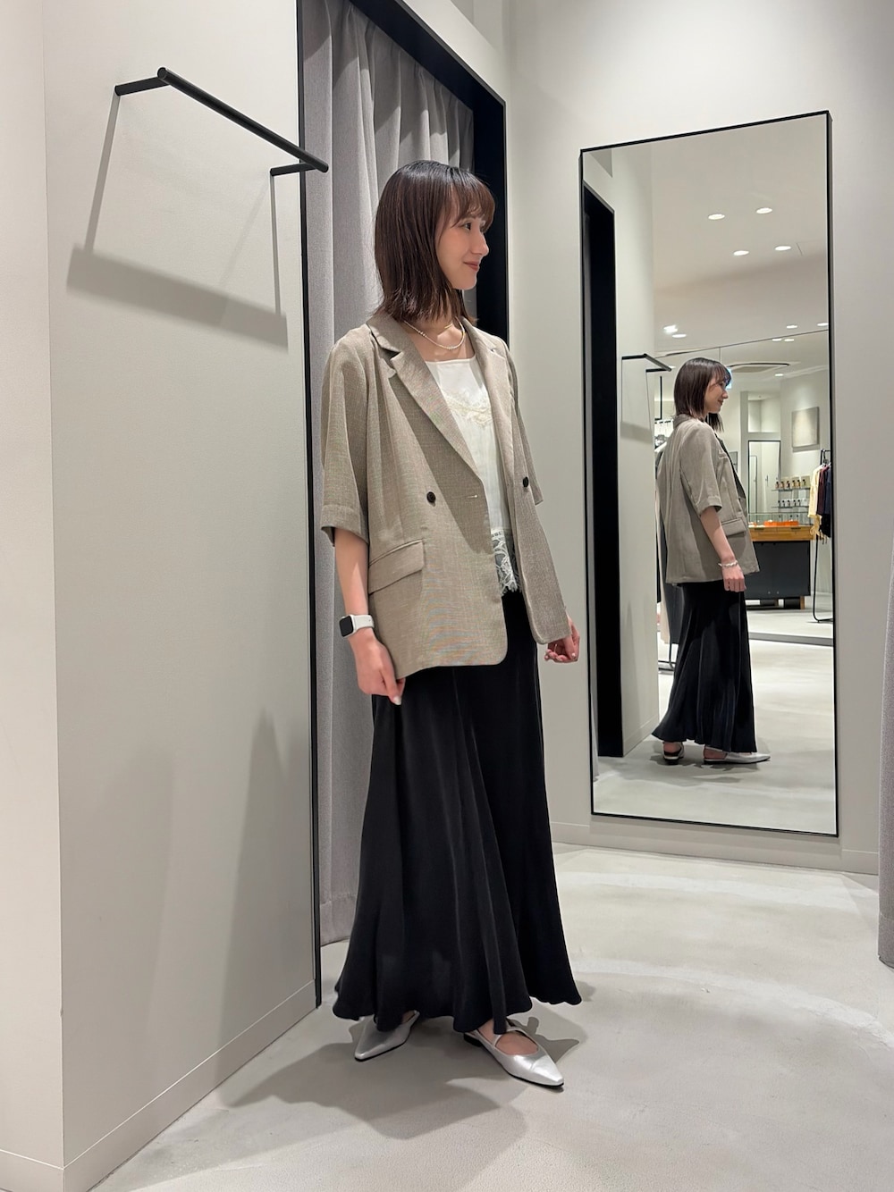 ベージュ系のその他アウター、グレー系のスカート、シルバー系のパンプスを着用したレディースの春コーディネートの1枚目の写真