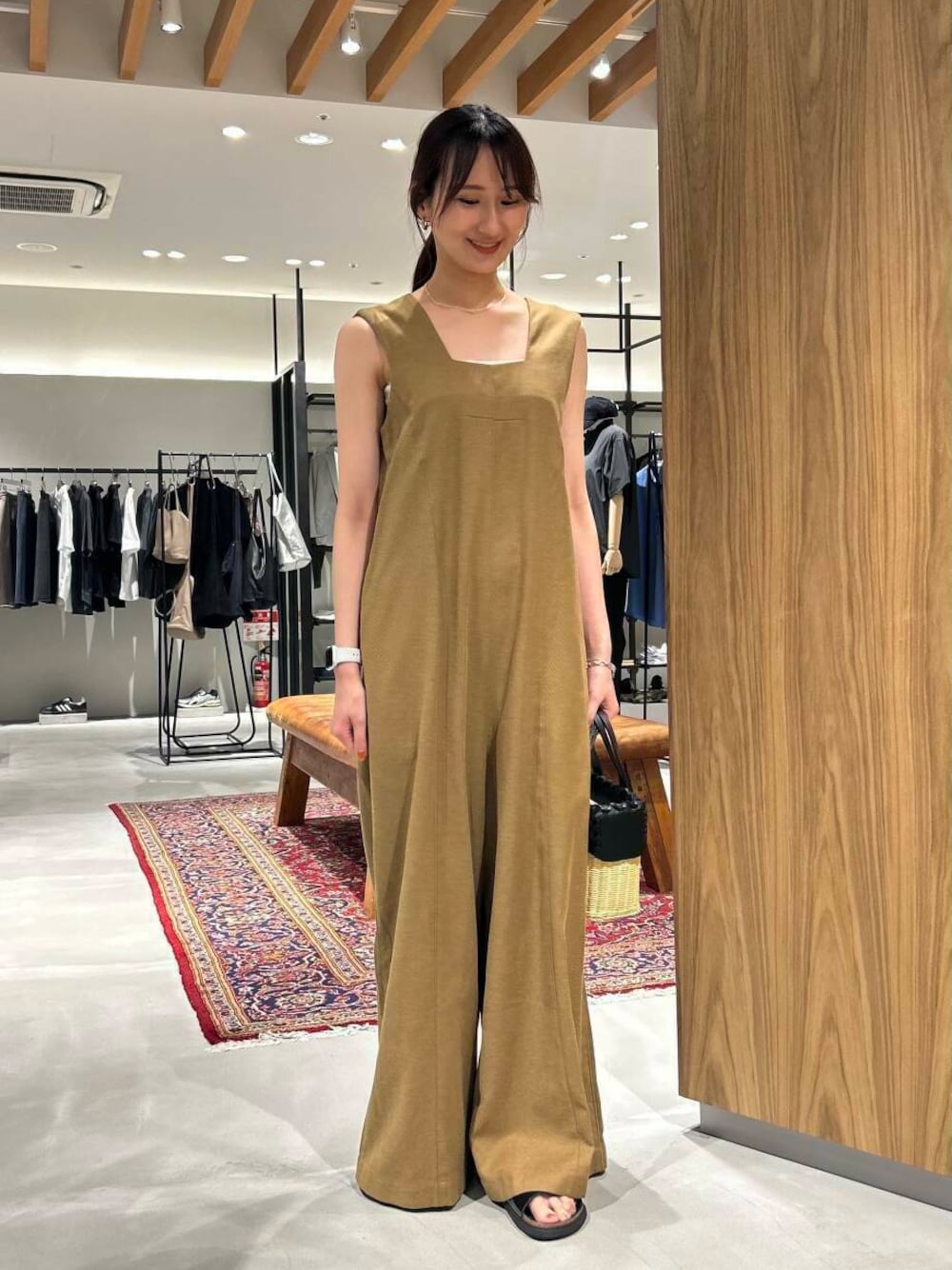 イエロー系のサロペット/オーバーオール、ブラック系のサンダルを着用したレディースの夏コーディネートの1枚目の写真