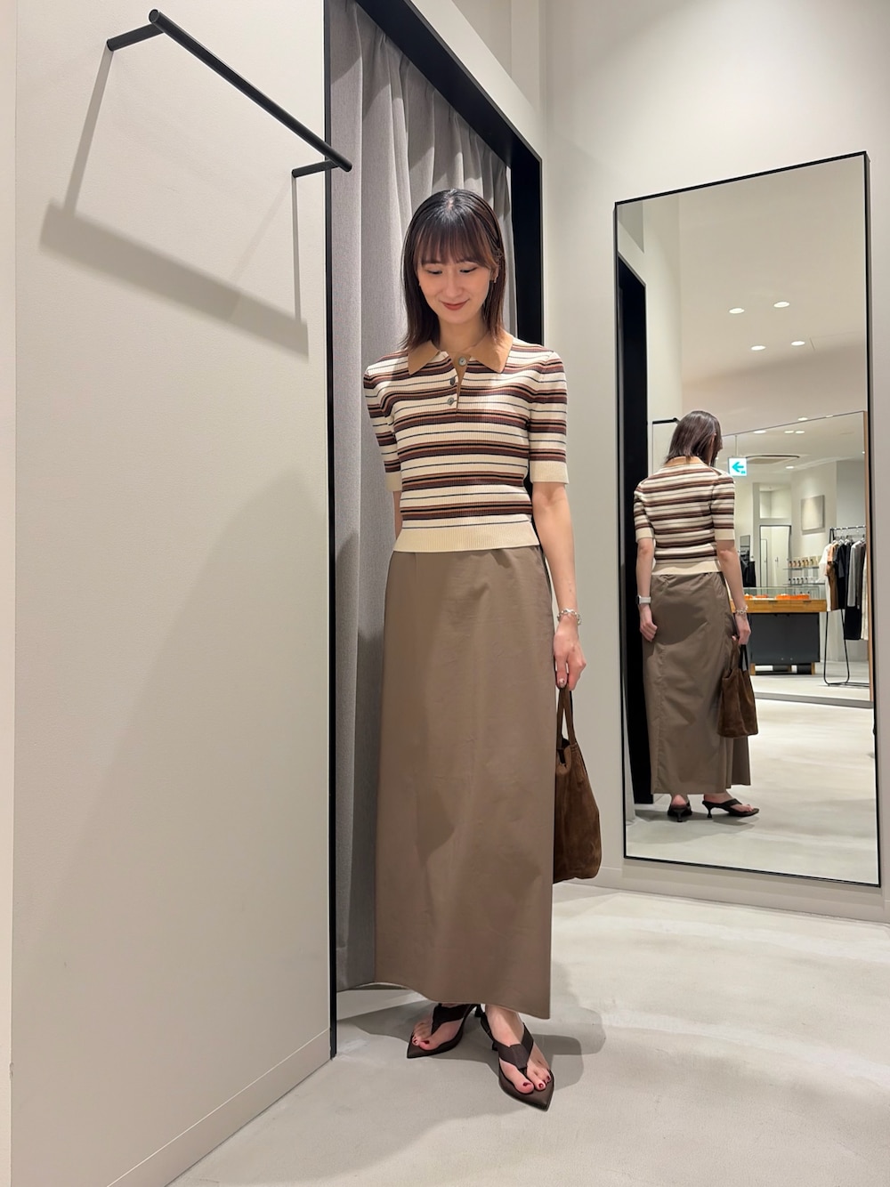 ホワイト系のニット/セーター、グレー系のスカート、ブラウン系のサンダルを着用したレディースの夏コーディネートの1枚目の写真