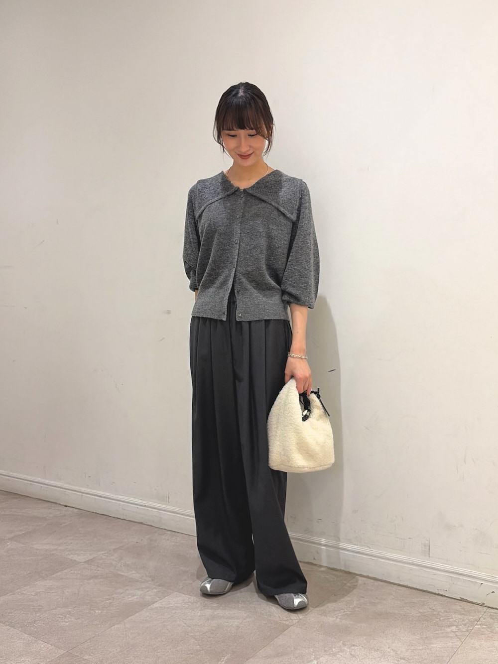 グレー系のニット/セーター、グレー系のその他パンツ、ホワイト系のハンドバッグを着用したレディースの秋コーディネートの1枚目の写真