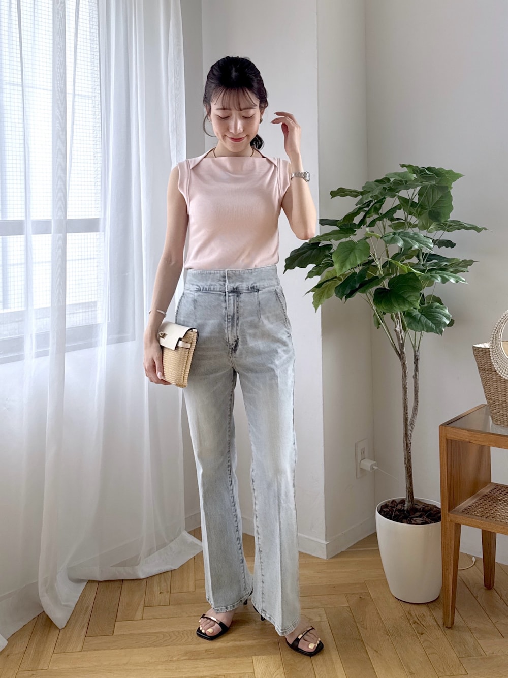 ピンク系のキャミソール、ブルー系のデニムパンツ、ブラック系のサンダルを着用したレディースの春コーディネートの1枚目の写真