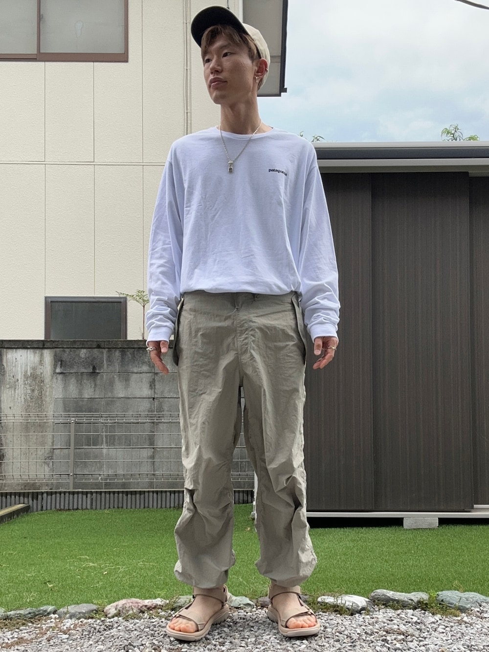 「patagonia、GU、teva、shein、キャップ、ロンT、パラシュートパンツ、スポーツサンダル、ベージュ、オーバーサイズ、タックイン、カジュアル、休日スタイル、WEARyouthコーデ、夏だ！Tシャツ着よう！」｜「patagoniaの【Patagonia/パタゴニア】ロゴプリントクルーネックロングTシャツ（Tシャツ/カットソー、ホワイト系）」を使った、おたけさん（メンズ・175cm）の夏コーディネートの1枚目の写真