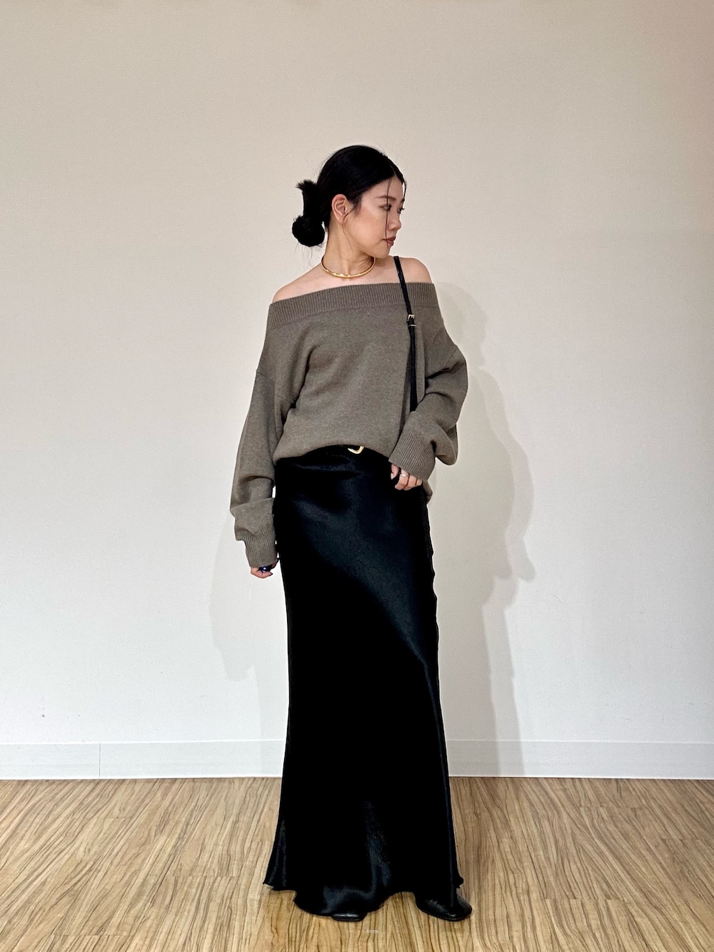 ブラウン系のニット/セーター、ブラック系のショルダーバッグ、ブラック系のブーツを着用したレディースの秋コーディネートの1枚目の写真