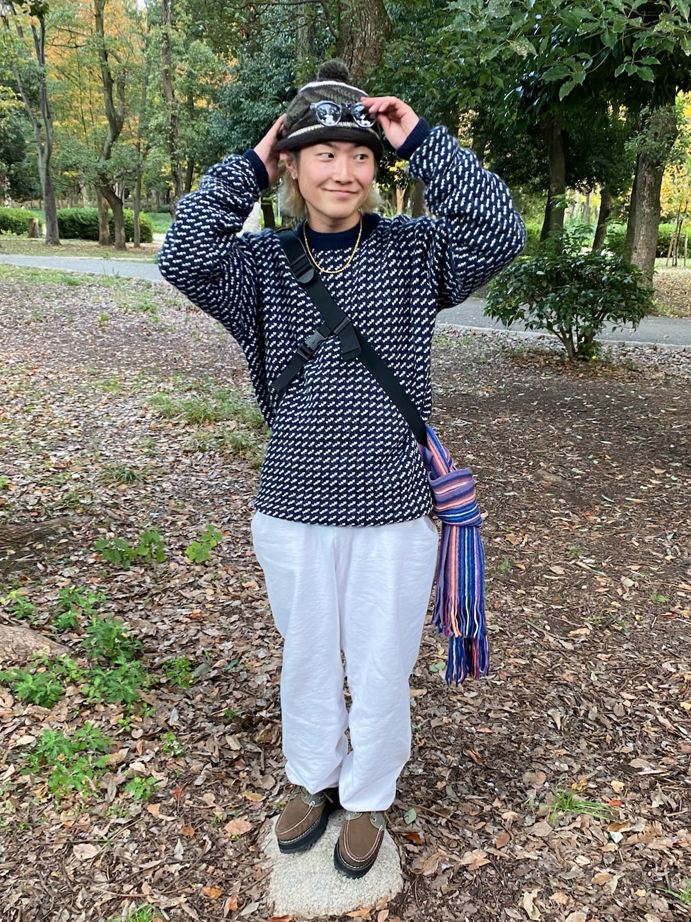 ブルー系のニット/セーター、ホワイト系のスウェットパンツ、ブラウン系のモカシン/デッキシューズを着用したメンズの秋コーディネートの1枚目の写真