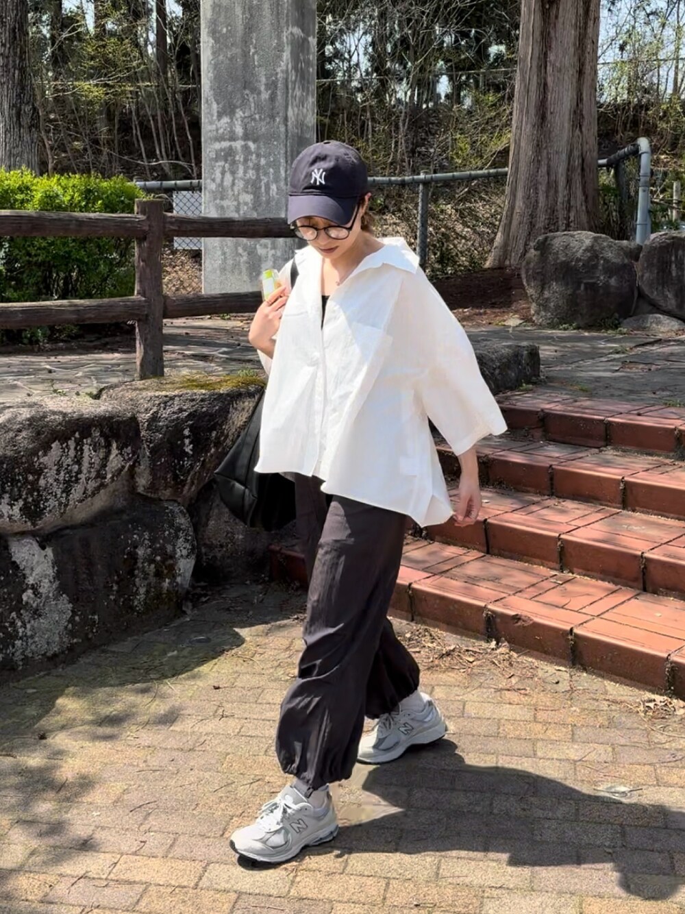 ホワイト系のシャツ/ブラウス、グレー系のその他パンツ、グレー系のスニーカーを着用したレディースの春コーディネートの1枚目の写真