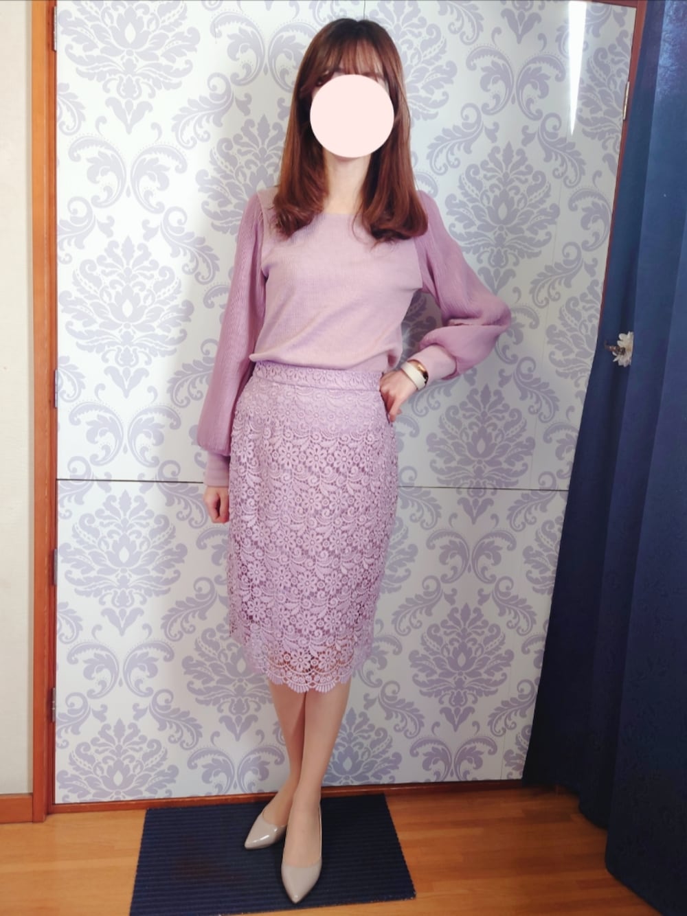 パープル系のスカート、パープル系のニット/セーター、ベージュ系のパンプスを着用したレディースの冬コーディネートの1枚目の写真