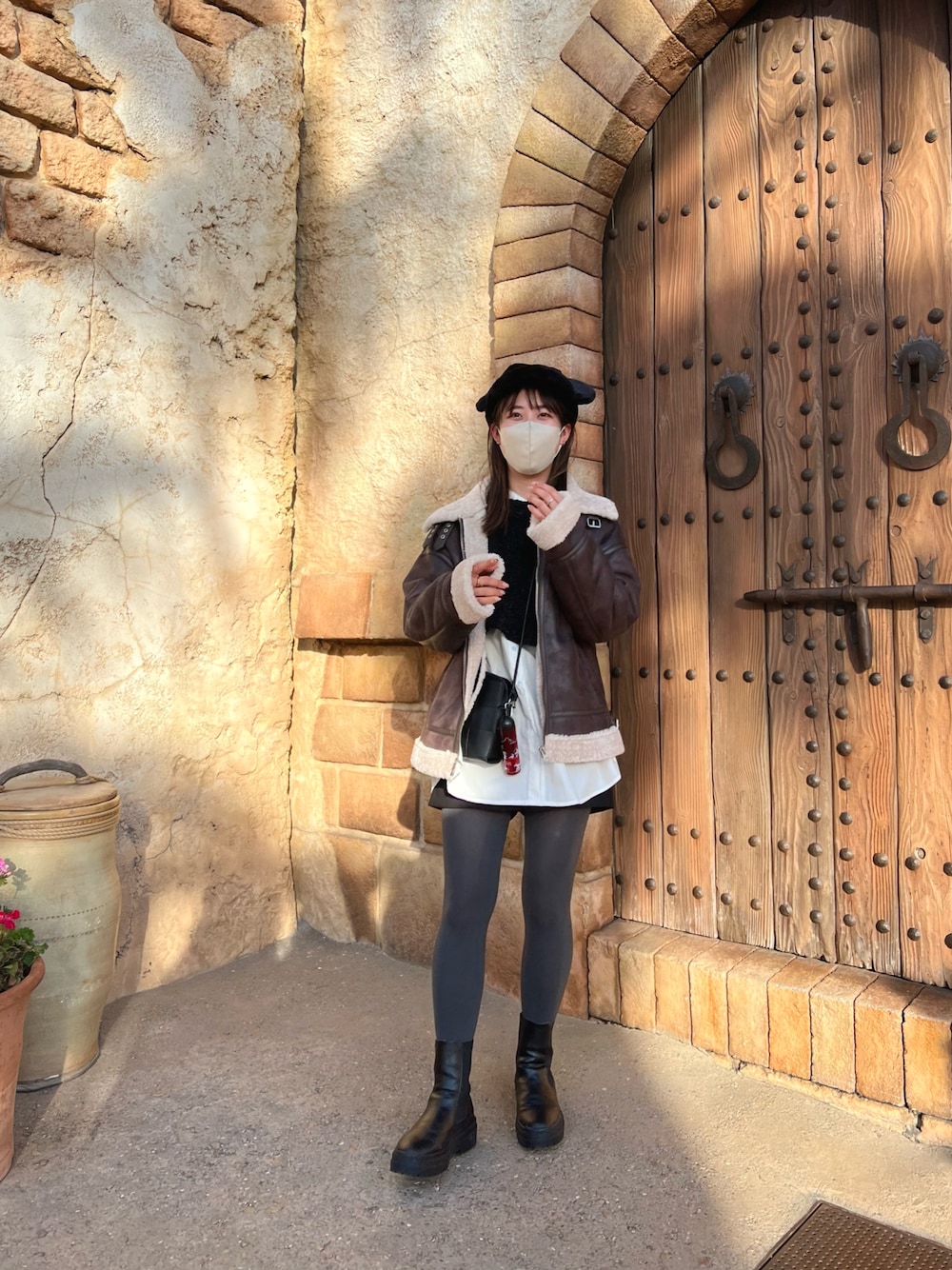 ブラック系のカーディガン/ボレロ、ブラック系のブーツ、ブラック系のショルダーバッグを着用したレディースの冬コーディネートの1枚目の写真