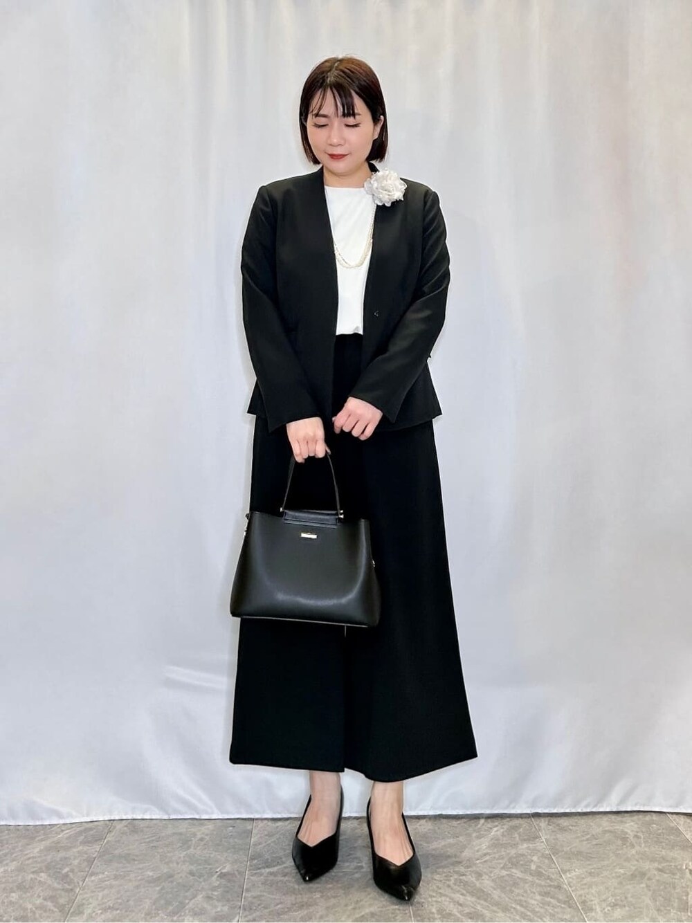 ブラック系のノーカラージャケット、ホワイト系のシャツ/ブラウス、ブラック系のその他パンツを着用したレディースの冬コーディネートの1枚目の写真
