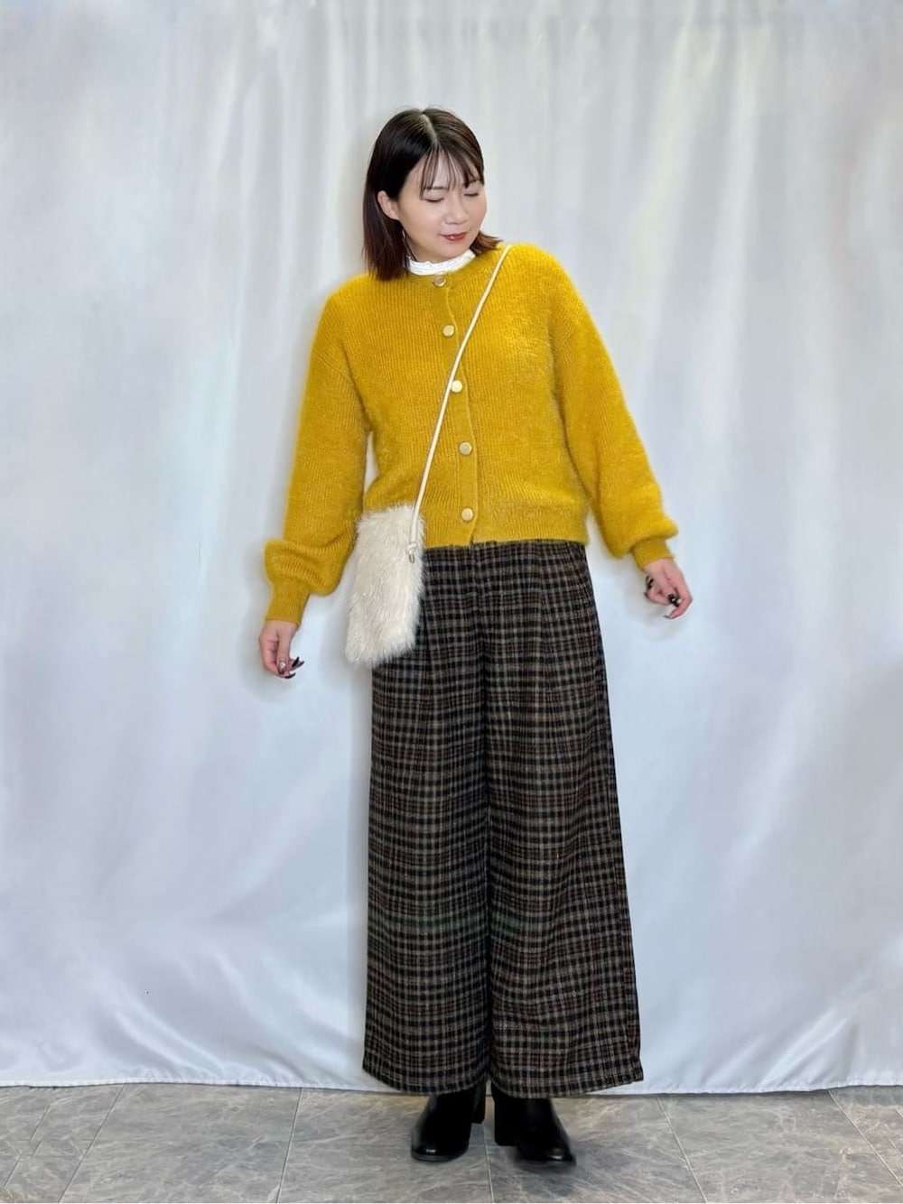 イエロー系のカーディガン/ボレロ、ホワイト系のTシャツ/カットソー、ブラック系のその他パンツを着用したレディースの冬コーディネートの1枚目の写真