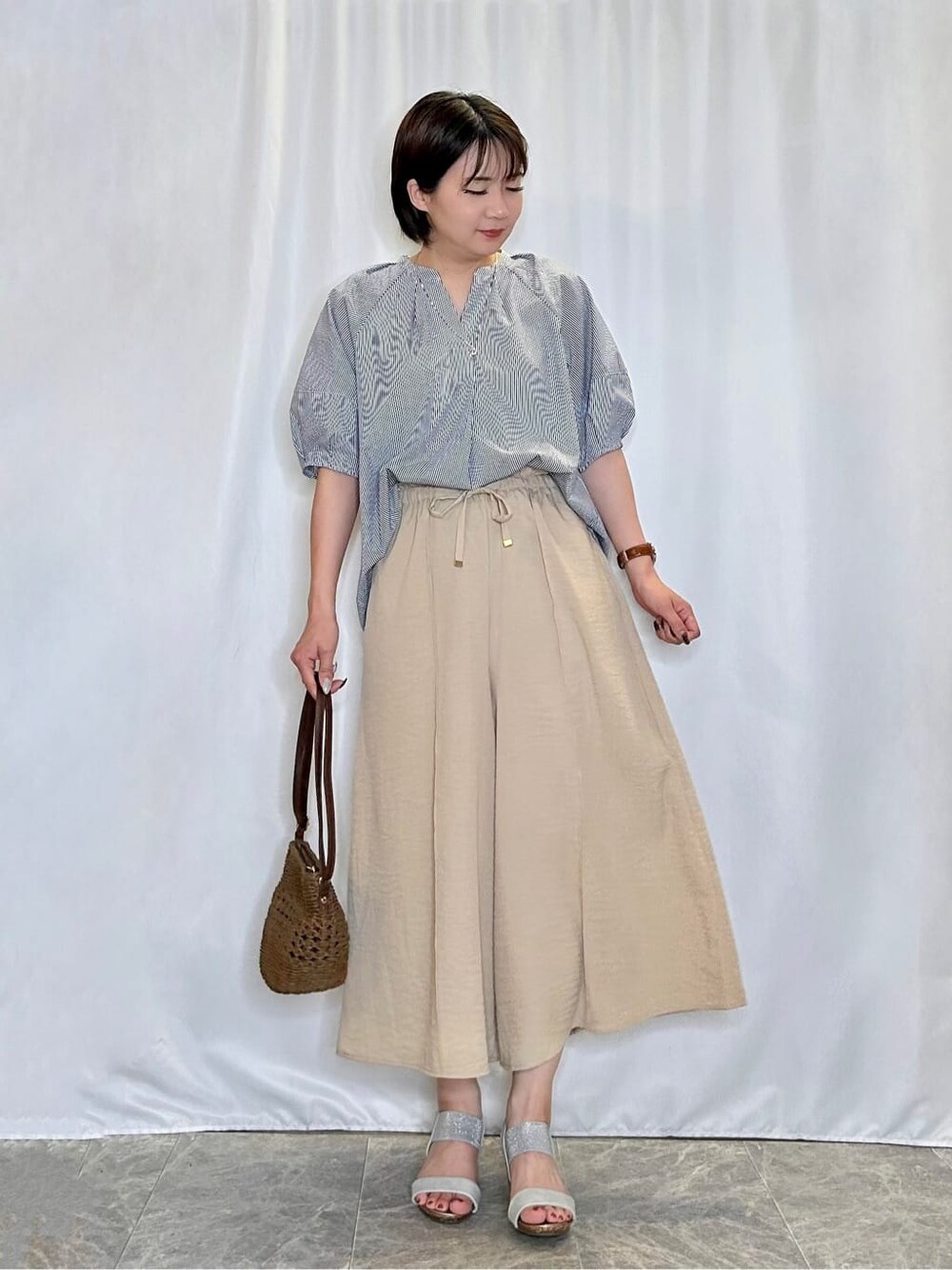 ブルー系のシャツ/ブラウス、ベージュ系のその他パンツ、シルバー系のサンダルを着用したレディースの夏コーディネートの1枚目の写真