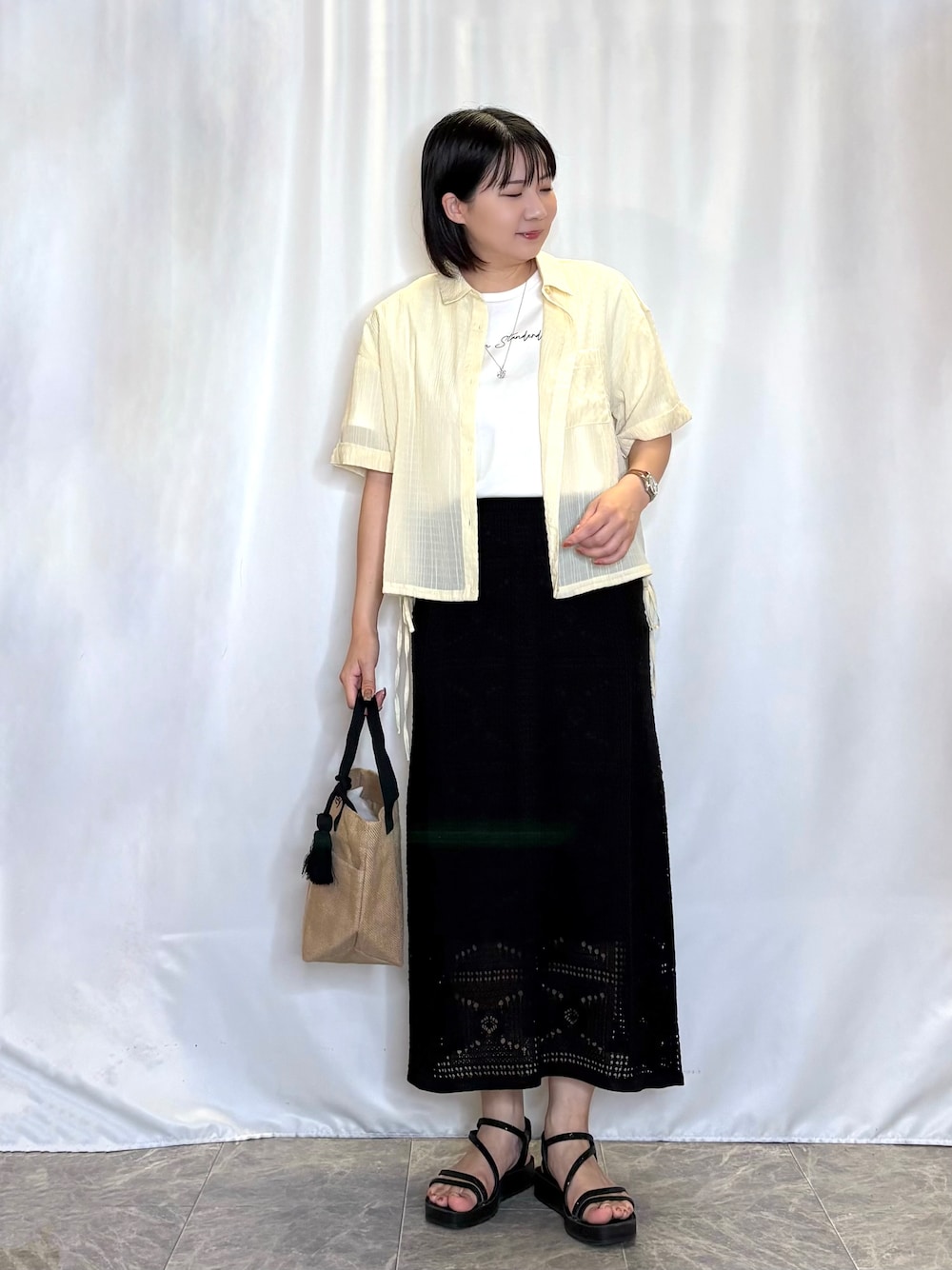 イエロー系のシャツ/ブラウス、ホワイト系のTシャツ/カットソー、ブラック系のスカートを着用したレディースの夏コーディネートの1枚目の写真