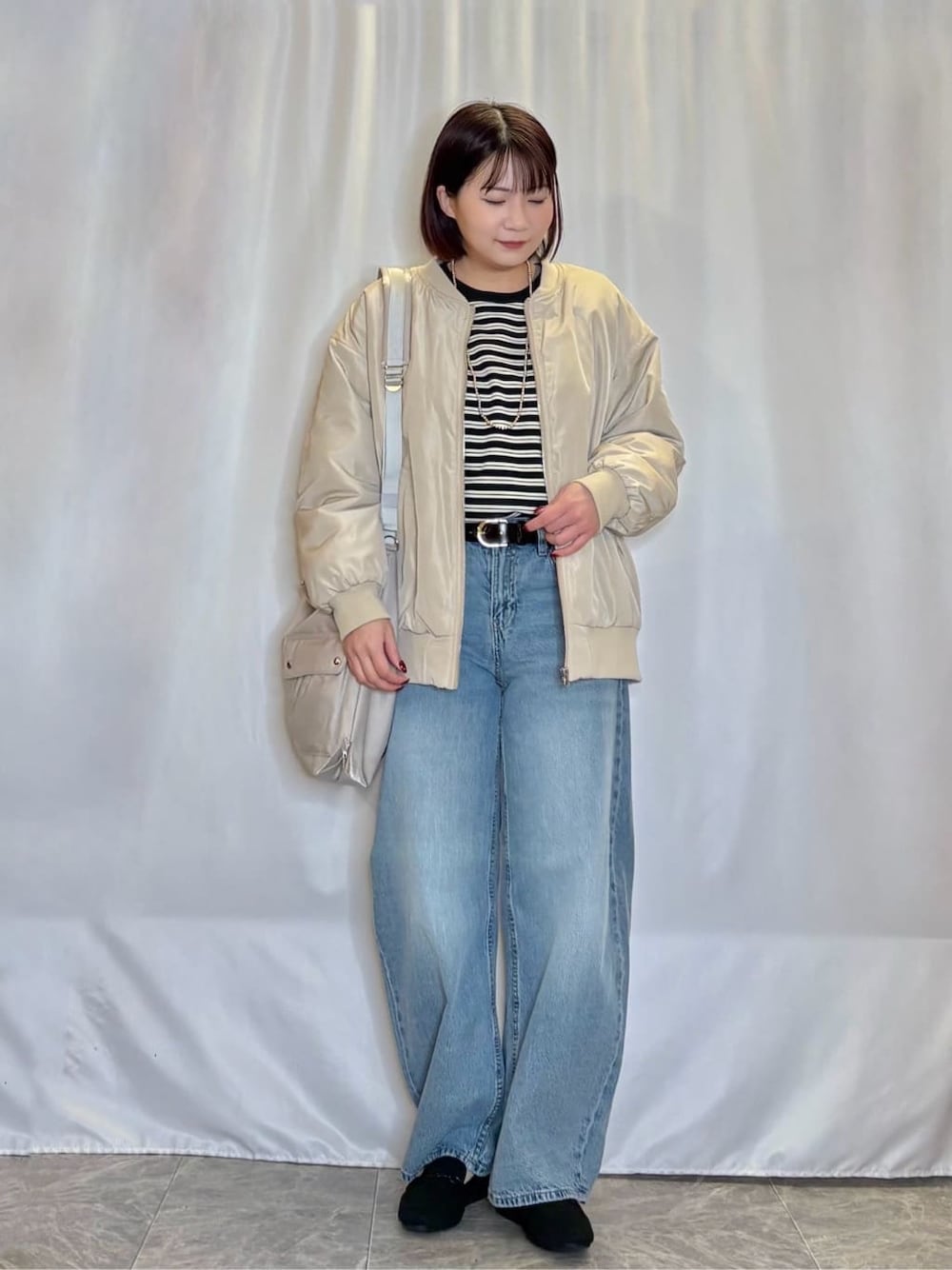 ベージュ系のブルゾン、ブラック系のTシャツ/カットソー、ブルー系のデニムパンツを着用したレディースの冬コーディネートの1枚目の写真