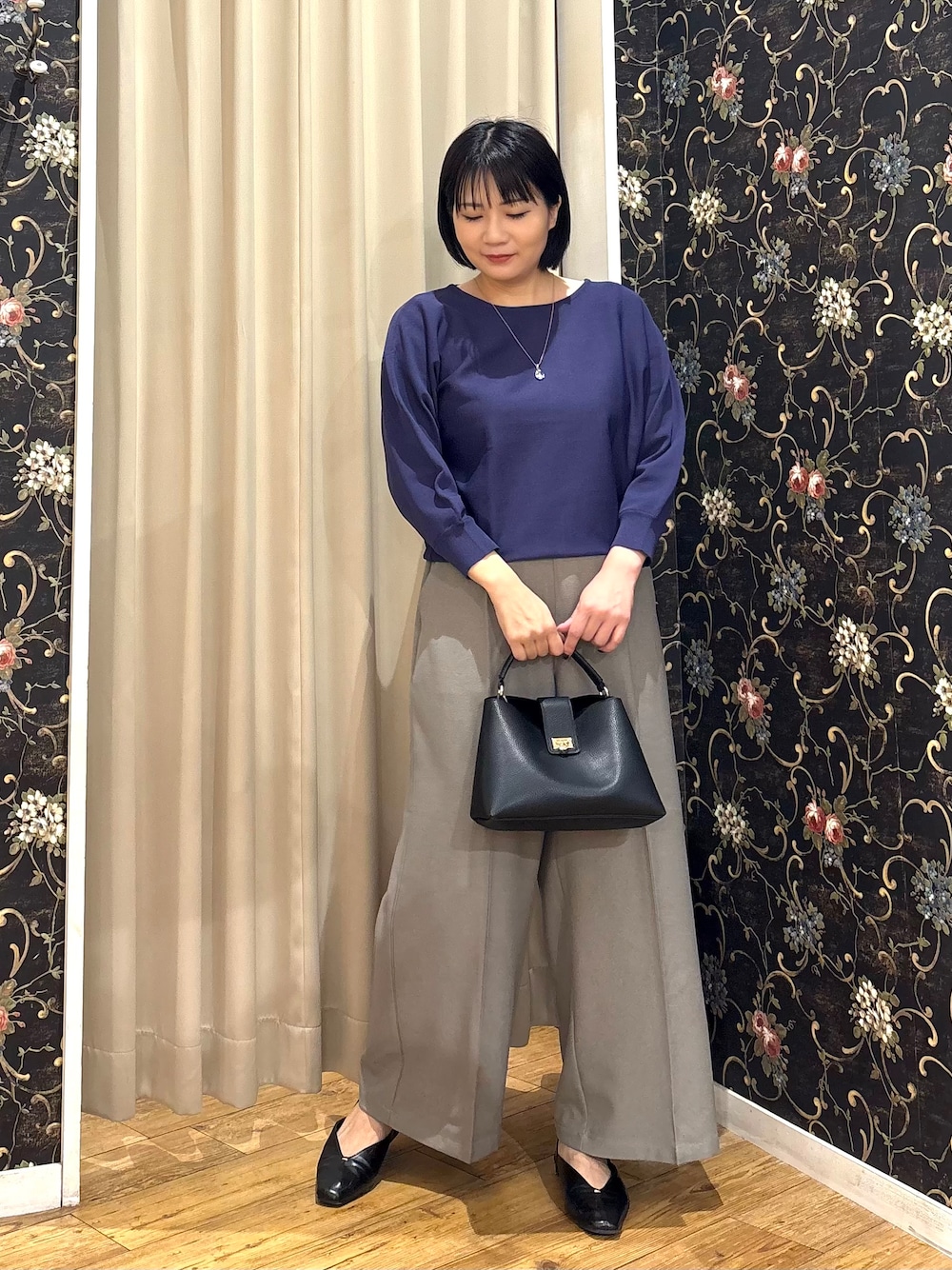 ブルー系のニット/セーター、ベージュ系のその他パンツ、ブラック系のショルダーバッグを着用したレディースの秋コーディネートの1枚目の写真