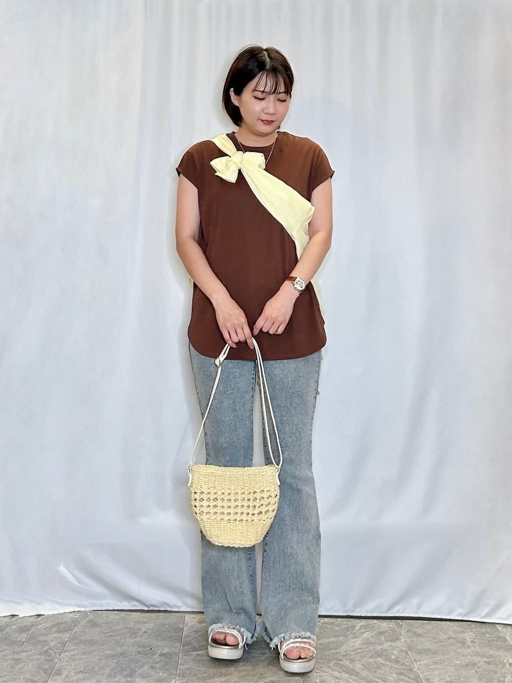 イエロー系のシャツ/ブラウス、ブラウン系のTシャツ/カットソー、ブルー系のデニムパンツを着用したレディースの夏コーディネートの1枚目の写真