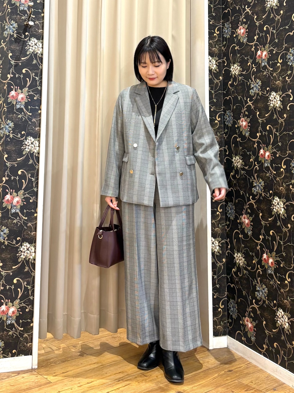 グレー系のテーラードジャケット、ブラック系のニット/セーター、グレー系のその他パンツを着用したレディースの秋コーディネートの1枚目の写真