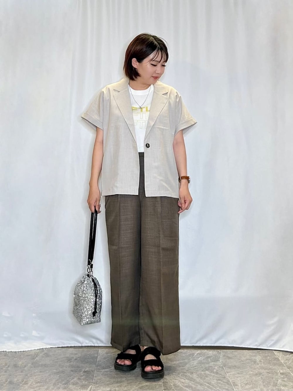ベージュ系のテーラードジャケット、ホワイト系のTシャツ/カットソー、ブラウン系のその他パンツを着用したレディースの夏コーディネートの1枚目の写真
