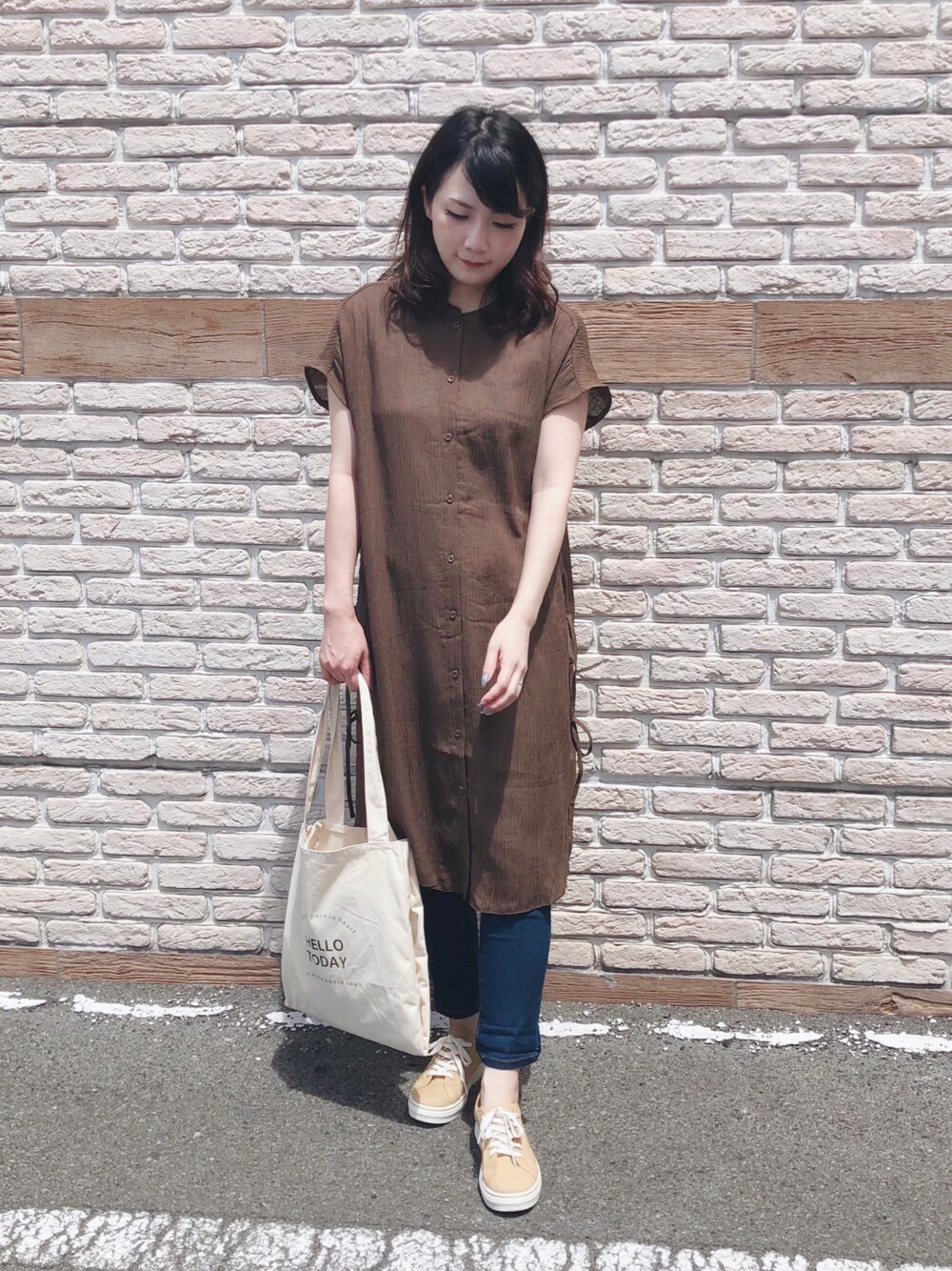 ブラウン系のワンピース、イエロー系のスニーカー、ホワイト系のトートバッグを着用したレディースの夏コーディネートの1枚目の写真