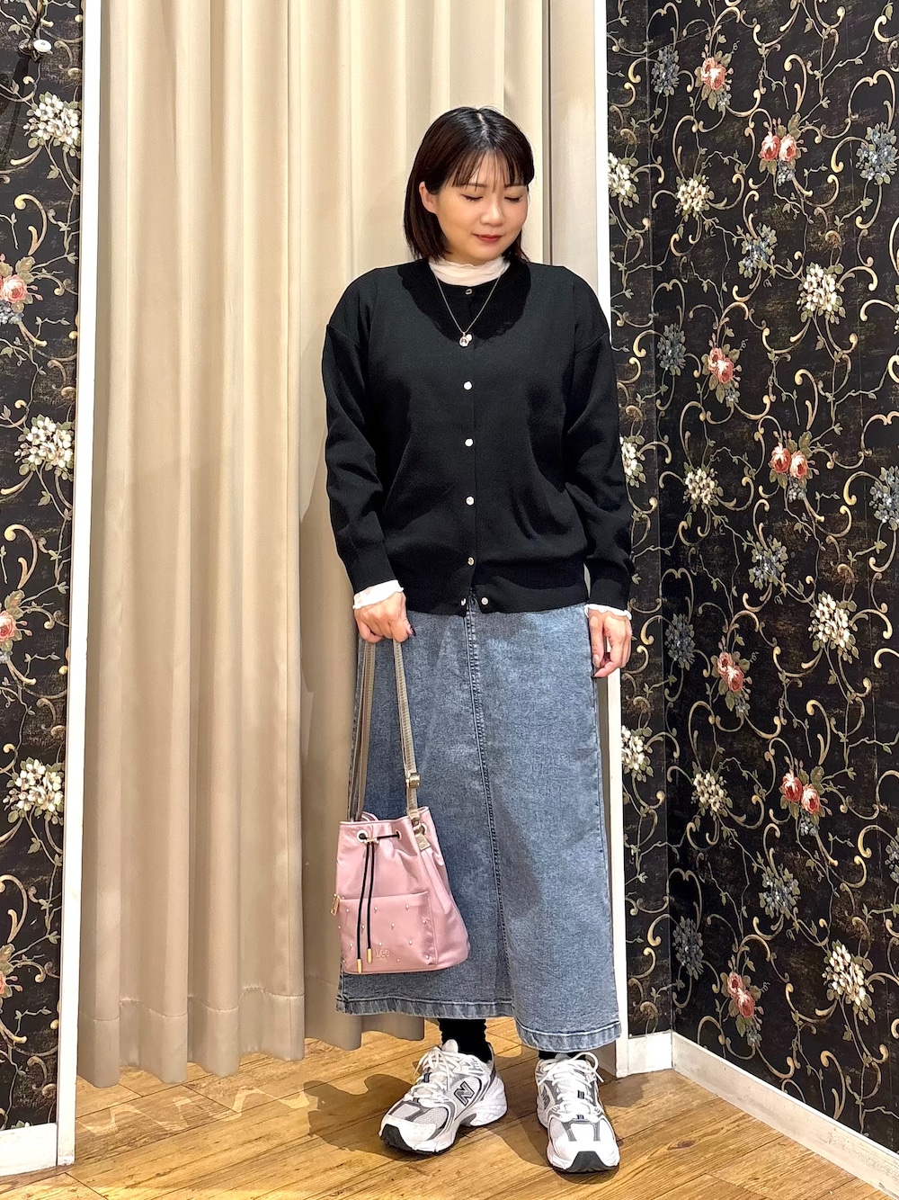 ブラック系のカーディガン/ボレロ、ホワイト系のTシャツ/カットソー、ブルー系のデニムスカートを着用したレディースの秋コーディネートの1枚目の写真