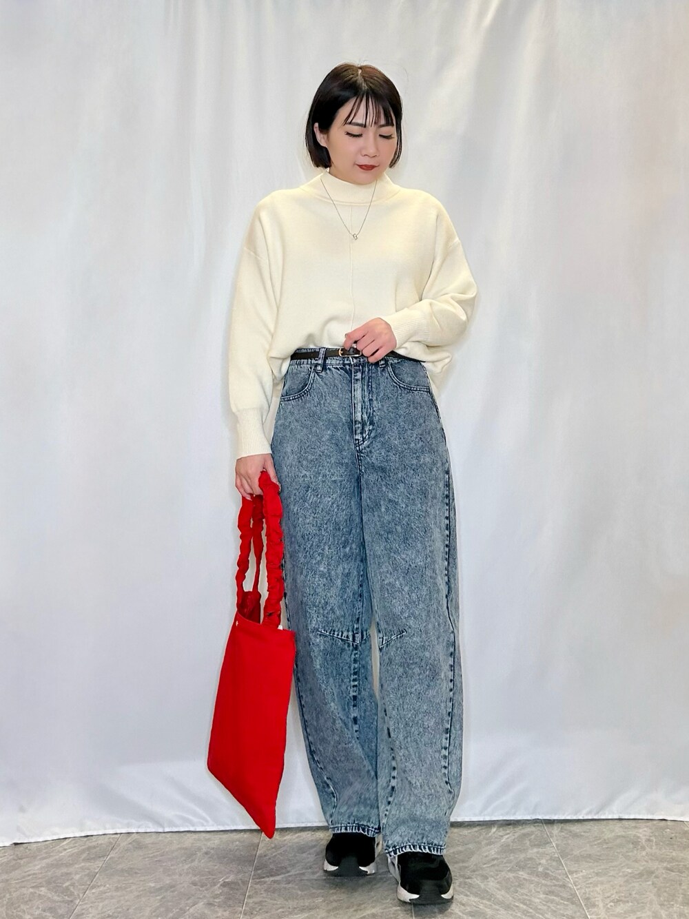 ブルー系のその他パンツ、レッド系のトートバッグ、ホワイト系のニット/セーターを着用したレディースの冬コーディネートの1枚目の写真