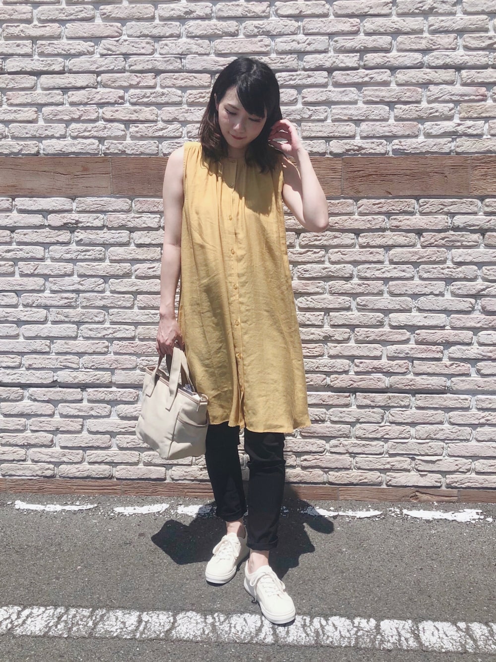 イエロー系のワンピース、ブラック系のその他パンツ、ベージュ系のトートバッグを着用したレディースの夏コーディネートの1枚目の写真