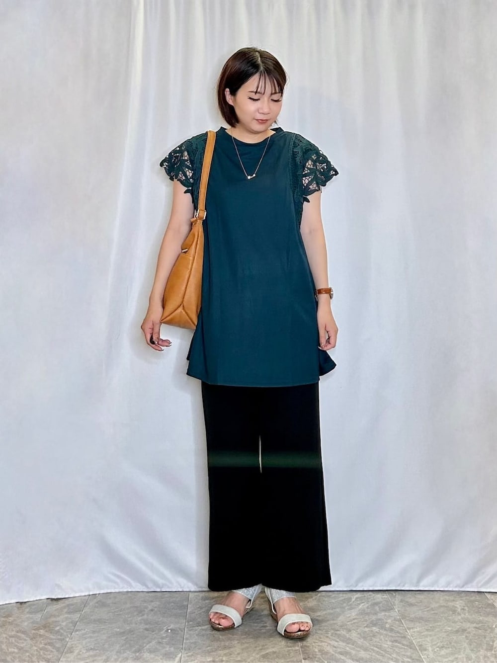 グリーン系のチュニック、ブラック系のその他パンツ、シルバー系のサンダルを着用したレディースの夏コーディネートの1枚目の写真