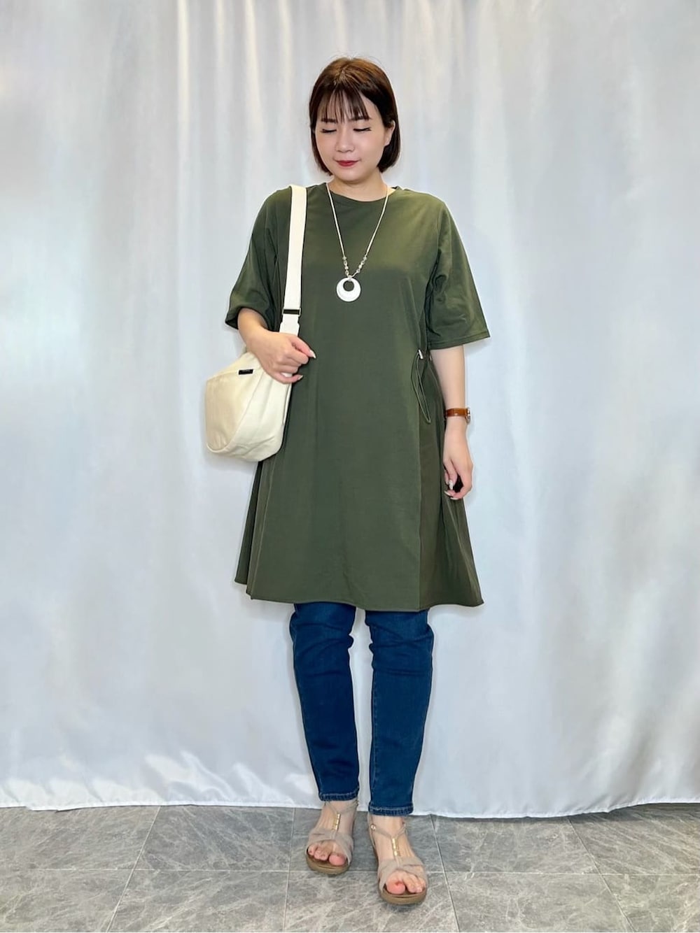 ブルー系のデニムパンツを着用したレディースの春コーディネートの1枚目の写真