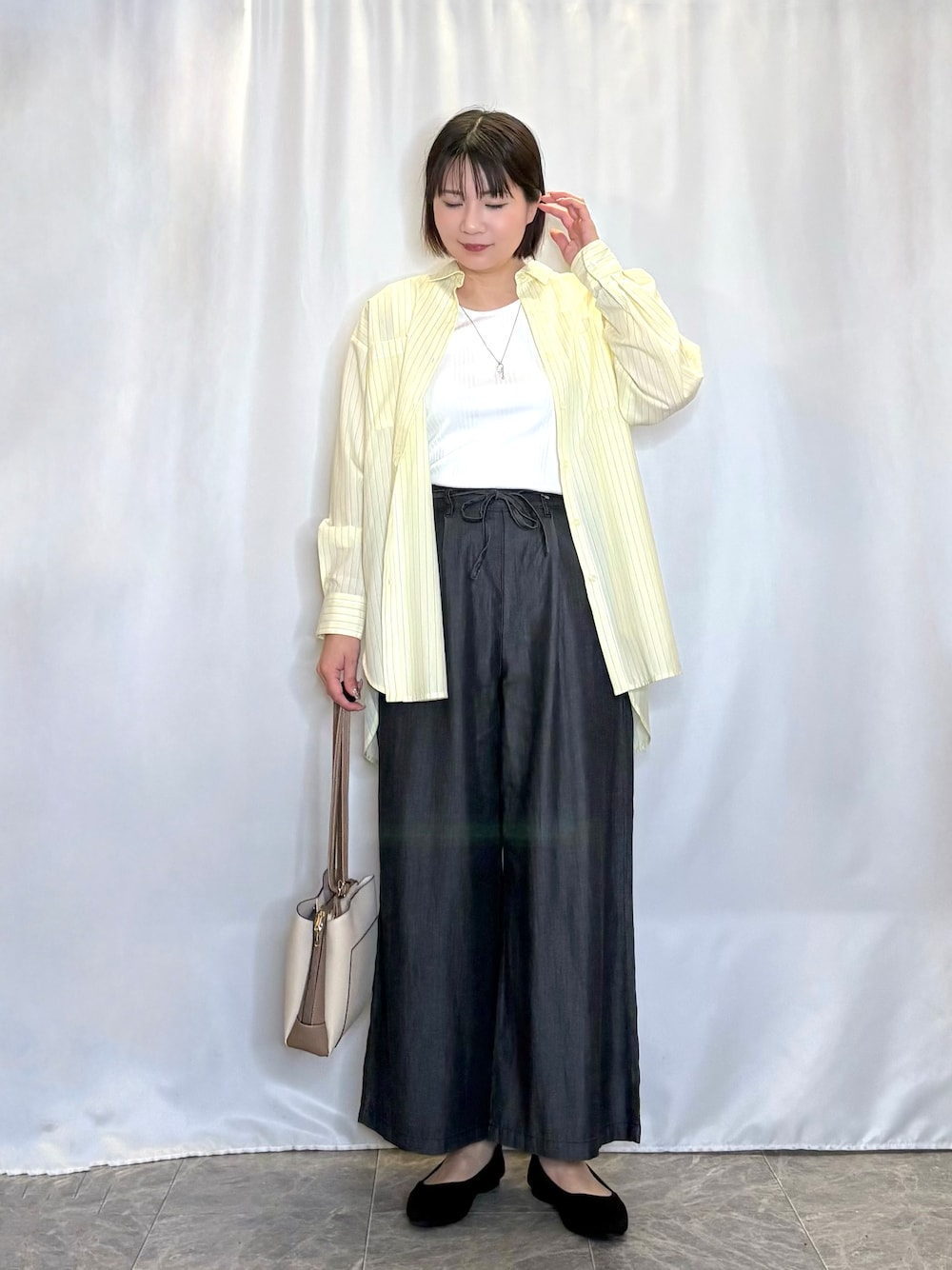 イエロー系のシャツ/ブラウス、ホワイト系のタンクトップ、ブラック系のその他パンツを着用したレディースの春コーディネートの1枚目の写真