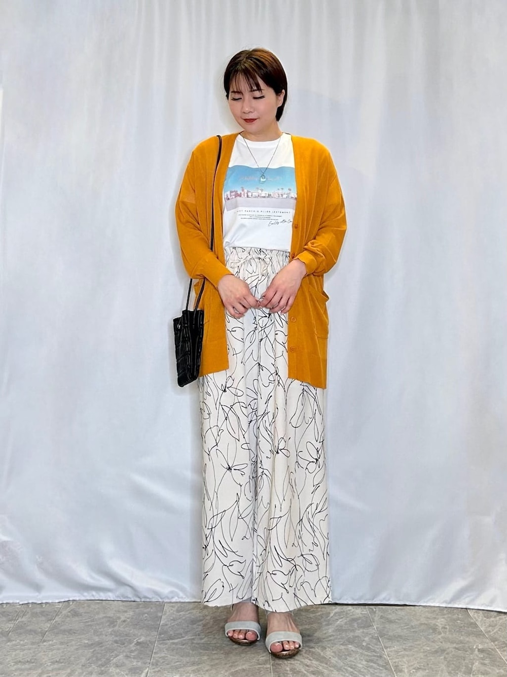 イエロー系のカーディガン/ボレロ、ホワイト系のその他パンツ、シルバー系のサンダルを着用したレディースの春コーディネートの1枚目の写真