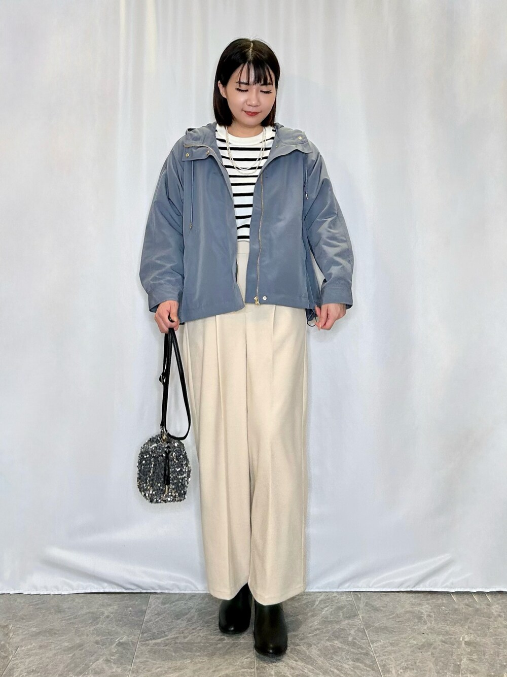 シルバー系のショルダーバッグ、ベージュ系のその他パンツ、ブラック系のブーツを着用したレディースの秋コーディネートの1枚目の写真