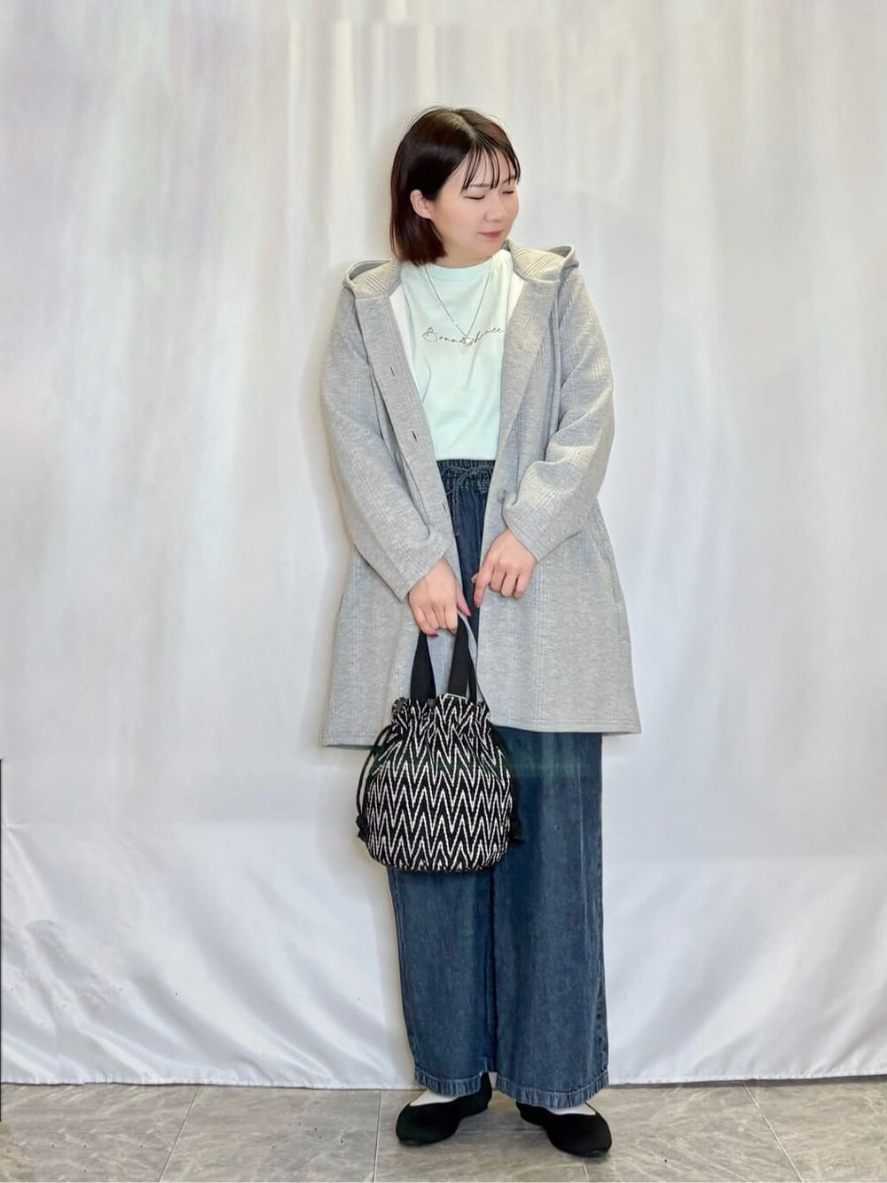 グレー系のその他アウター、グリーン系のTシャツ/カットソー、ブルー系のデニムパンツを着用したレディースの春コーディネートの1枚目の写真