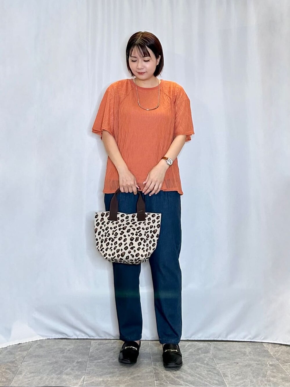 レッド系のTシャツ/カットソー、ブルー系のデニムパンツ、ブラック系のその他シューズを着用したレディースの秋コーディネートの1枚目の写真
