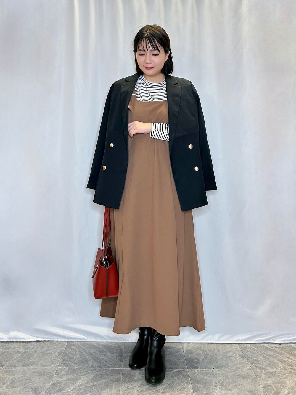 ブルー系のテーラードジャケット、レッド系のショルダーバッグ、ブラック系のブーツを着用したレディースの秋コーディネートの1枚目の写真