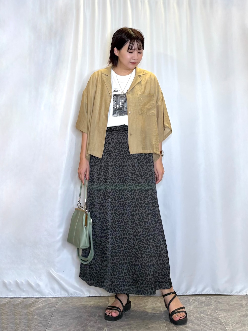 ブラウン系のシャツ/ブラウス、ホワイト系のTシャツ/カットソー、グレー系のスカートを着用したレディースの夏コーディネートの1枚目の写真