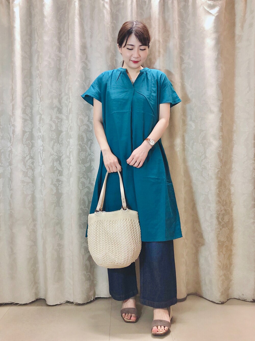 グリーン系のワンピース、ブラウン系のサンダル、ベージュ系のタンクトップを着用したレディースの春コーディネートの1枚目の写真