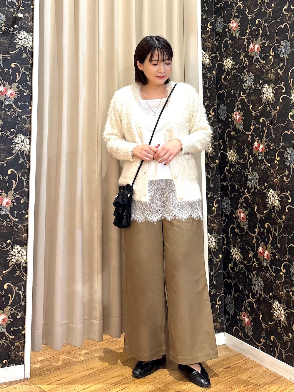 ホワイト系のカーディガン/ボレロ、ホワイト系のタンクトップ、ベージュ系のその他パンツを着用したレディースの秋コーディネートの1枚目の写真