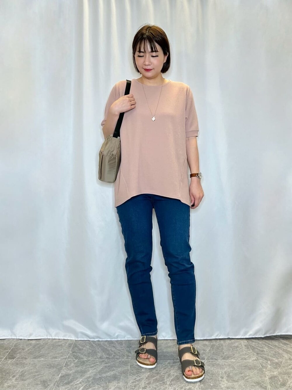 ブルー系のデニムパンツを着用したレディースの春コーディネートの1枚目の写真