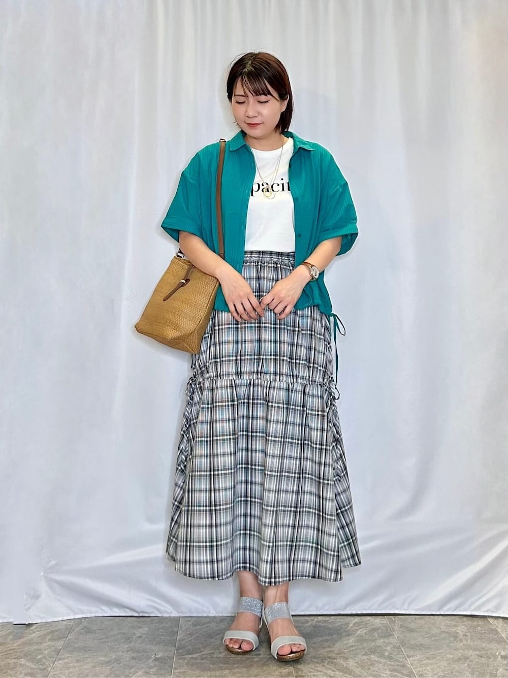 グリーン系のシャツ/ブラウス、ホワイト系のTシャツ/カットソー、ブラック系のスカートを着用したレディースの夏コーディネートの1枚目の写真