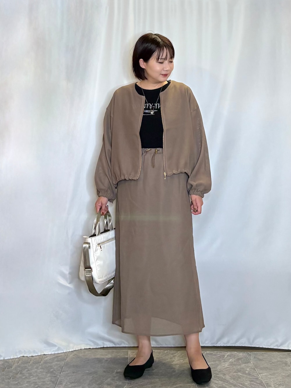 ブラウン系のブルゾン、ブラック系のTシャツ/カットソー、ブラウン系のスカートを着用したレディースの夏コーディネートの1枚目の写真
