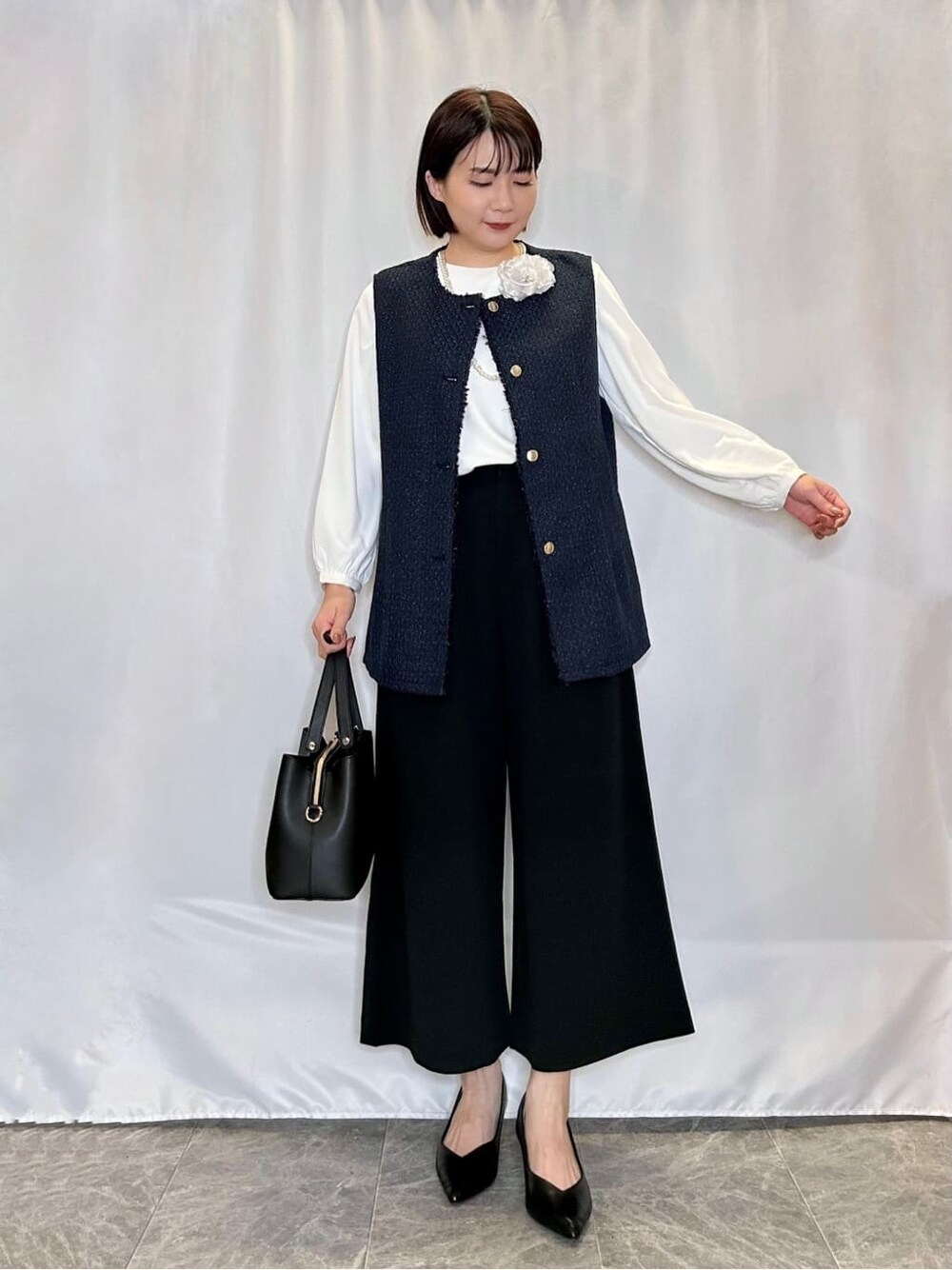 ブルー系のベスト、ホワイト系のシャツ/ブラウス、ブラック系のその他パンツを着用したレディースの冬コーディネートの1枚目の写真