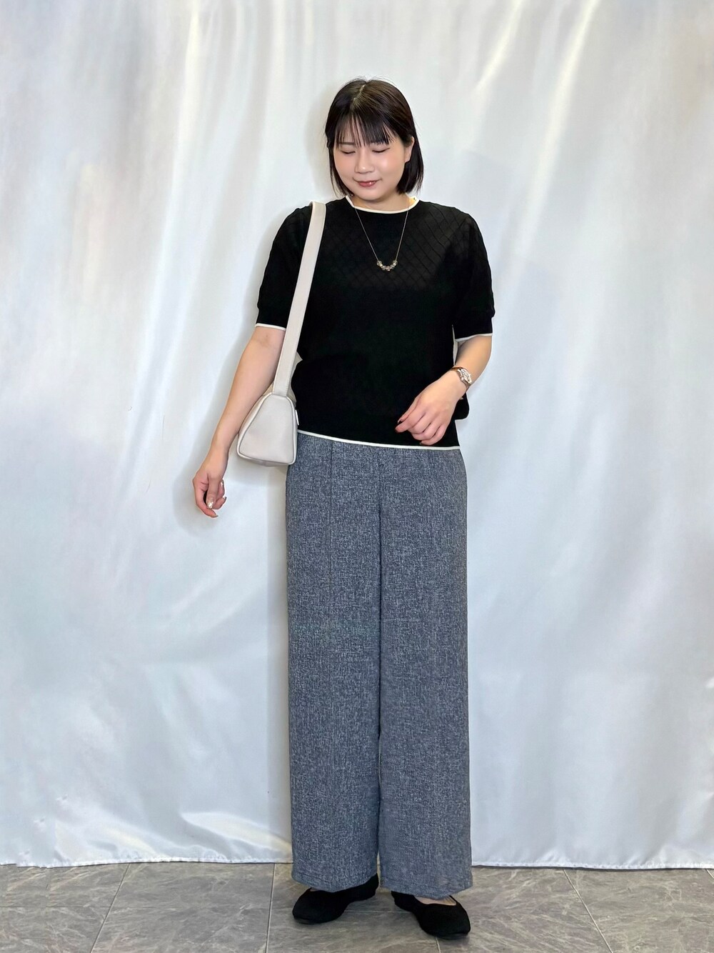 ブラック系のニット/セーター、ブルー系のその他パンツ、ブラック系のパンプスを着用したレディースの夏コーディネートの1枚目の写真