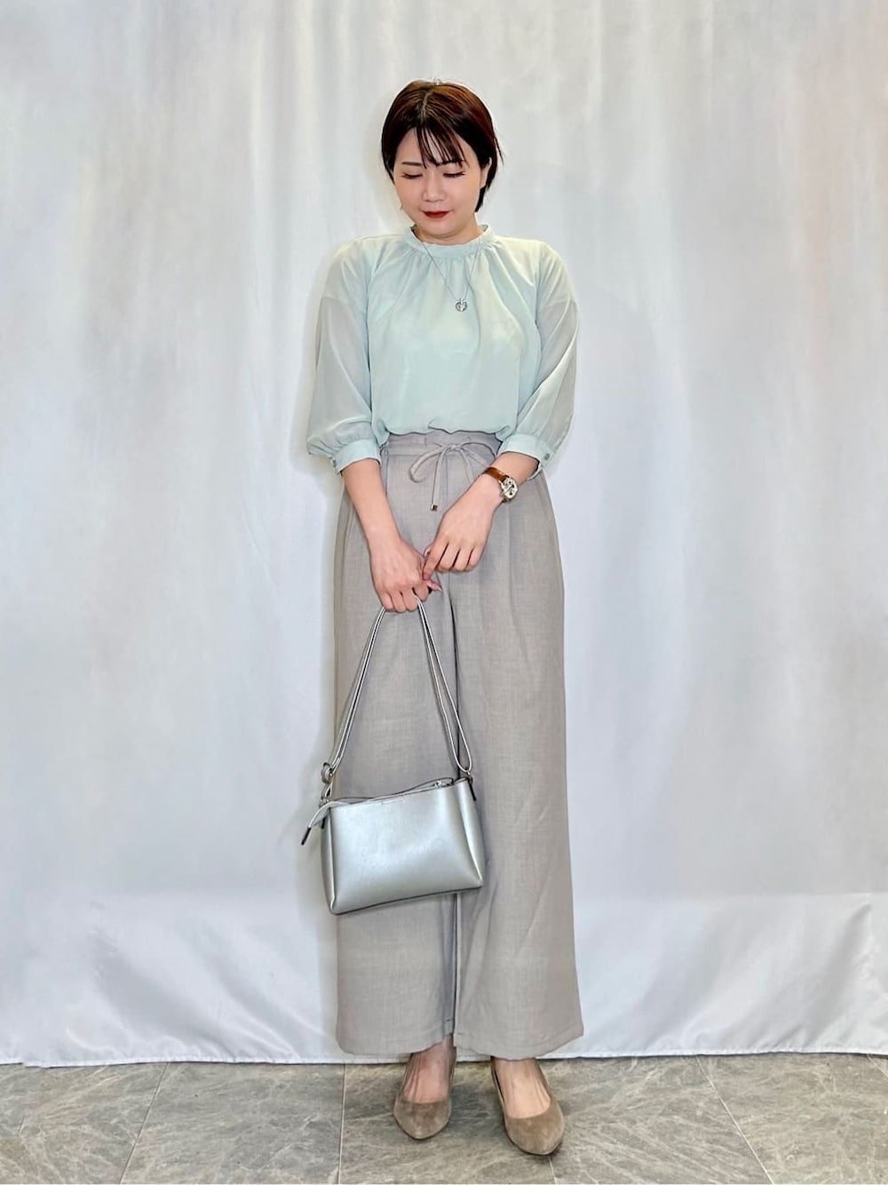 グリーン系のシャツ/ブラウス、ベージュ系のその他パンツ、シルバー系のショルダーバッグを着用したレディースの春コーディネートの1枚目の写真