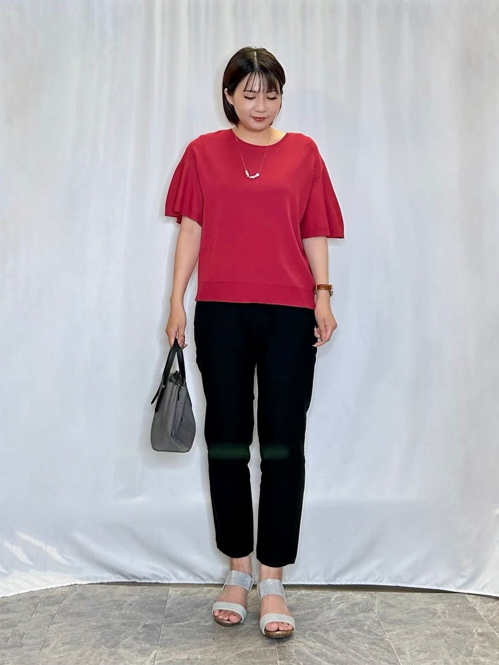 レッド系のニット/セーター、ブラック系のその他パンツ、シルバー系のサンダルを着用したレディースの夏コーディネートの1枚目の写真