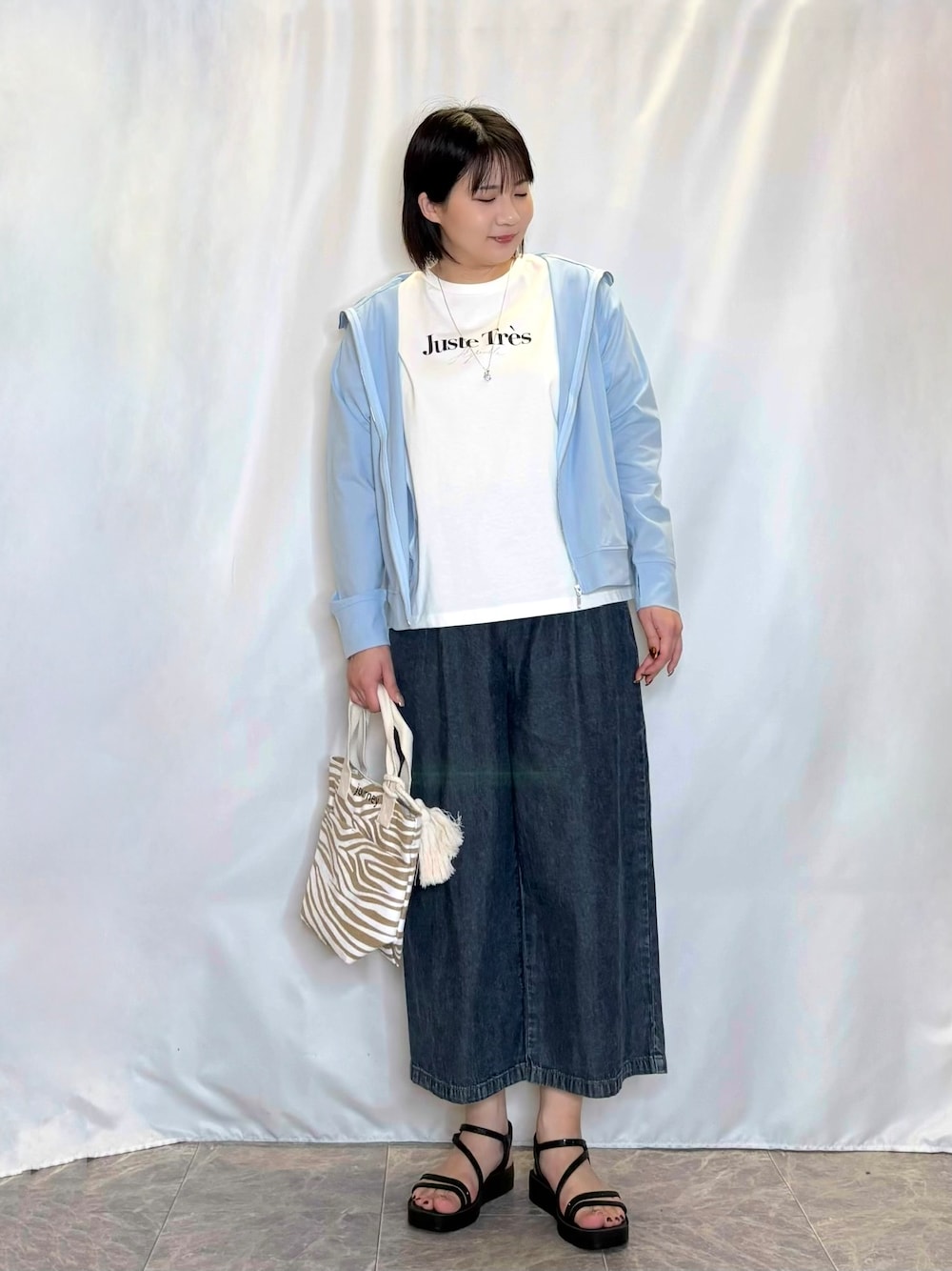 ブルー系のパーカー、ホワイト系のTシャツ/カットソー、ブルー系のデニムパンツを着用したレディースの春コーディネートの1枚目の写真